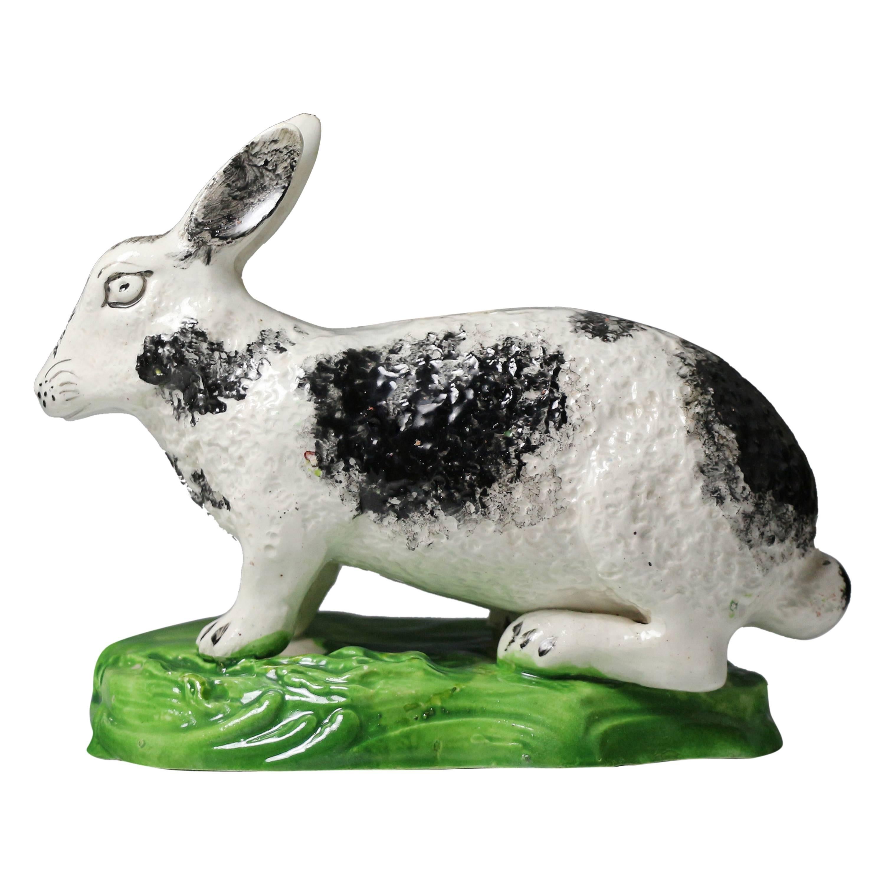 English pottery figure a rabbit on green oval base. c1840