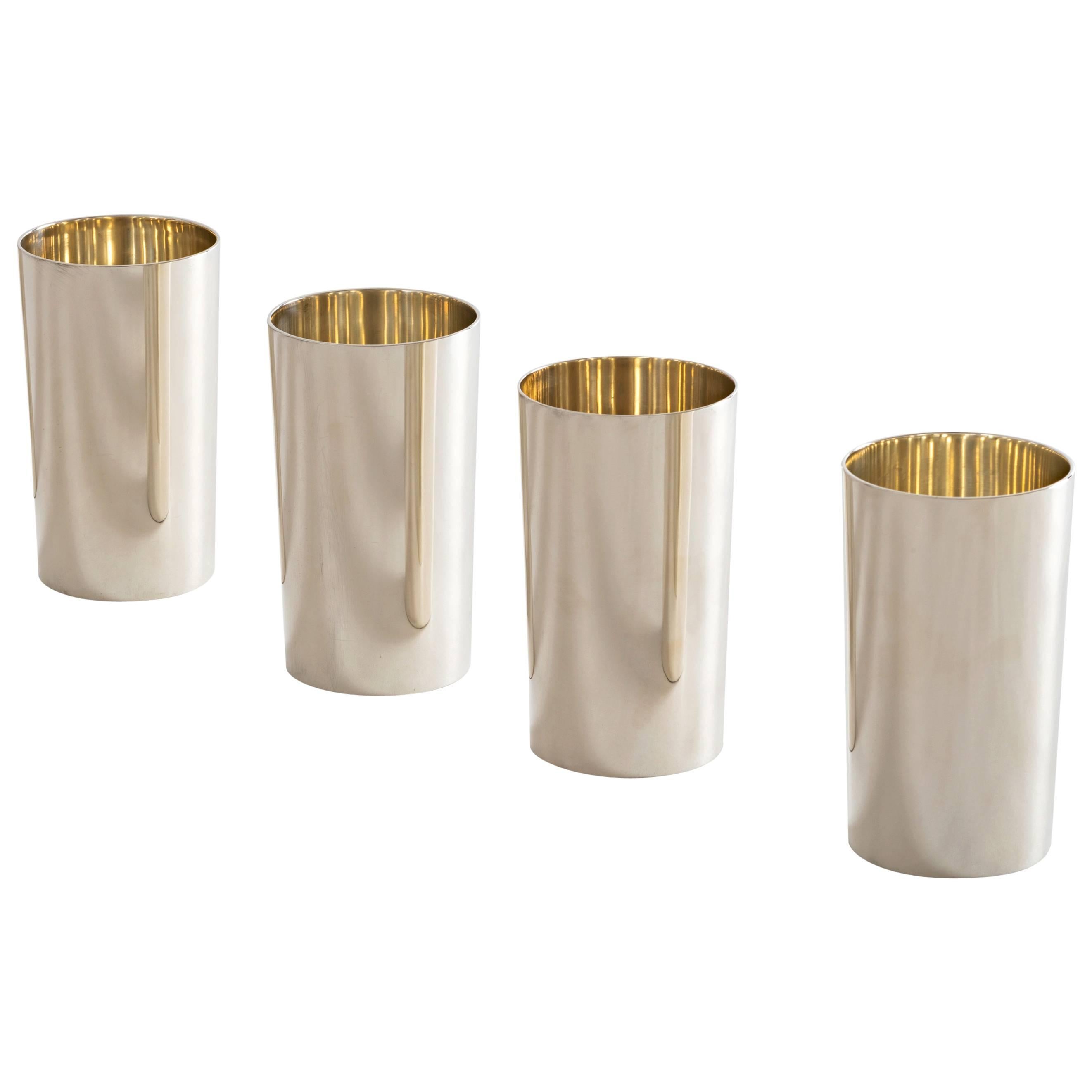 A set of four flawlessly modern mint julep cups / highball tumblers in sterling silver by Tiffany. Their spartan form and exceptional weight provide for an incredible feel in the hand. They also make beautiful vases. Incredibly clean and were likely