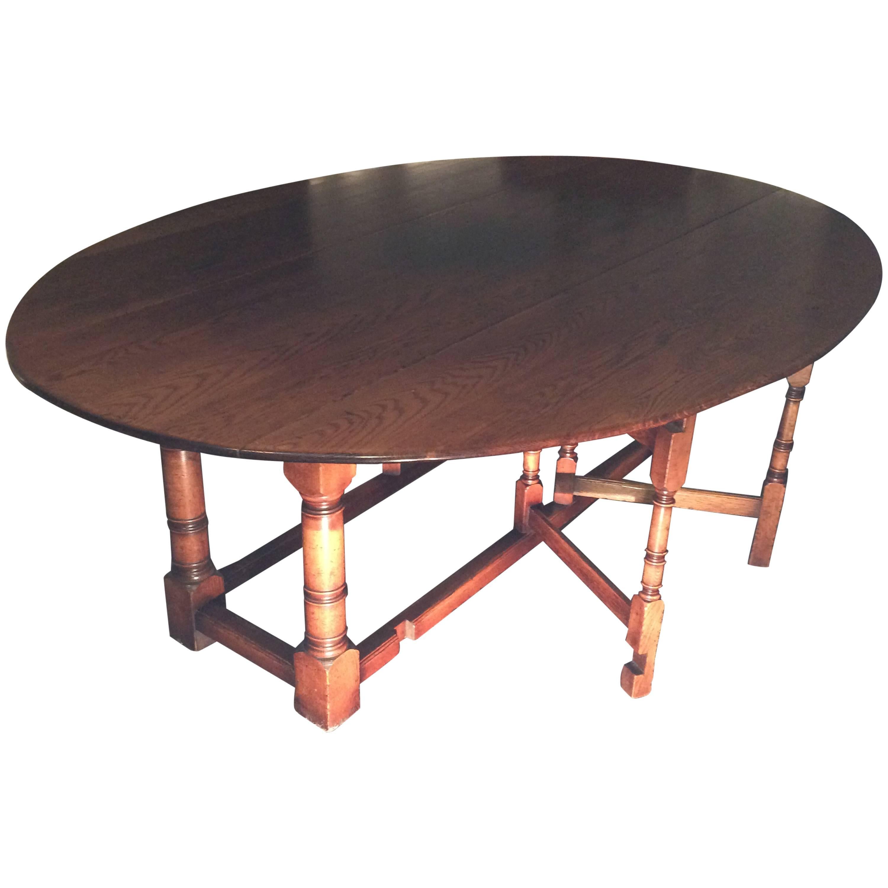 English oak gate leg wake table. Oval in shape when fully extended. Can be used as dining table, sofa table, or console; late 20th century. 

Open: 30