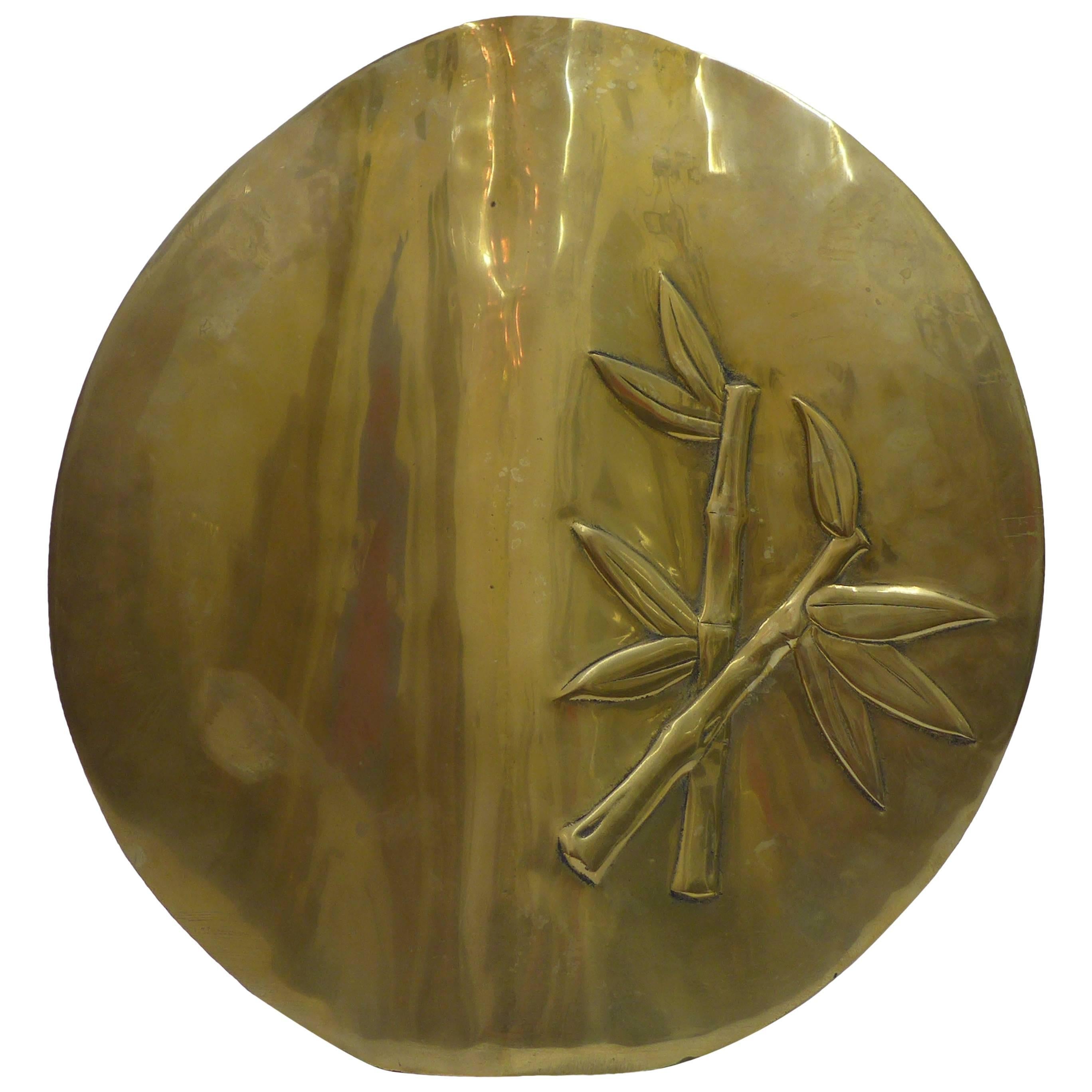 Sculptural brass vase with raised bamboo shoot design.