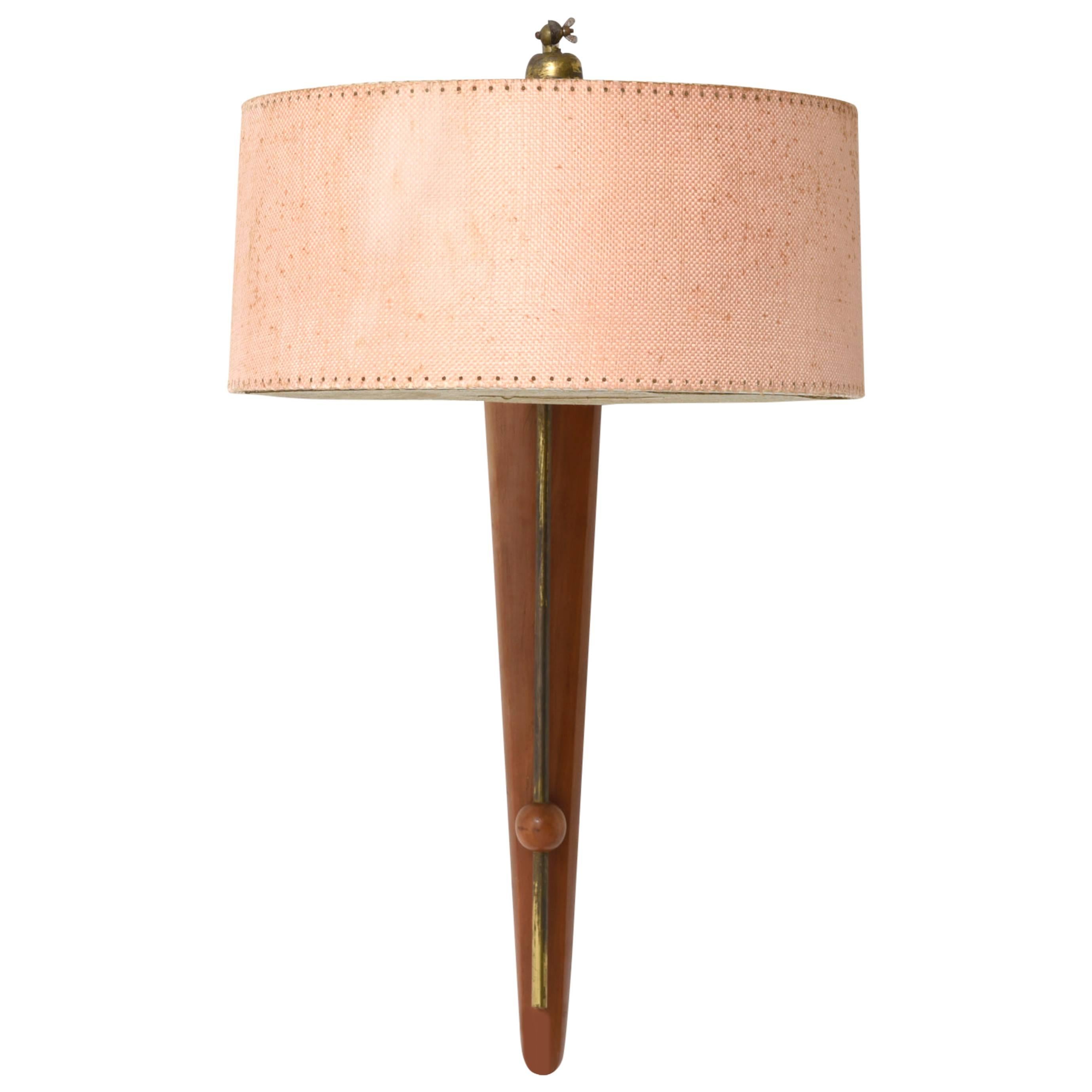 Elegant teakwood wall lamp with brass elements and fabric shade.
