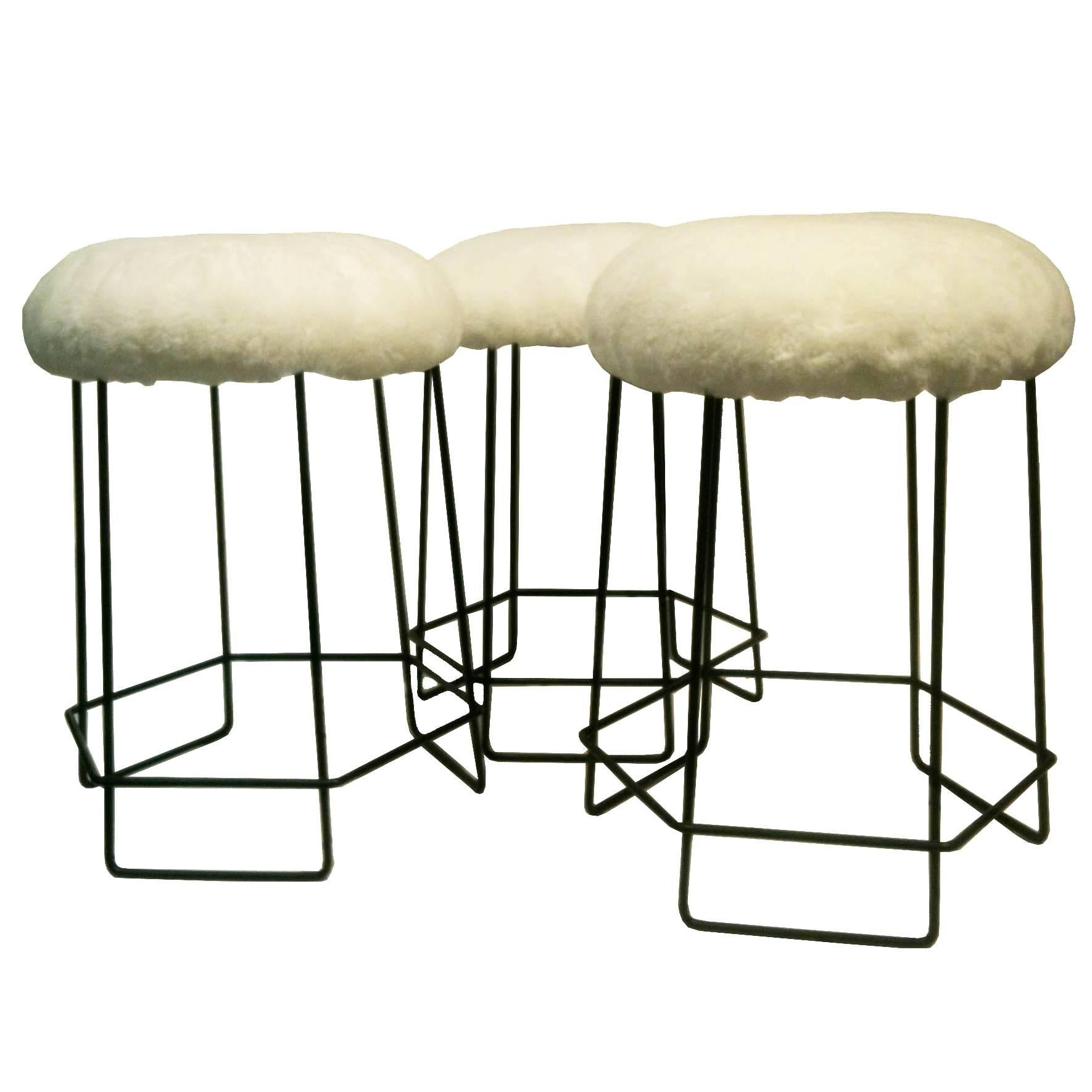 A Set of Three Black Wire and Shearling Stools in the style of Jean Royere