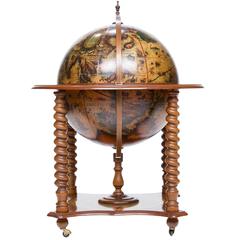 Un globe terrestre décoré sur pied s'ouvrant pour le rangement du bar