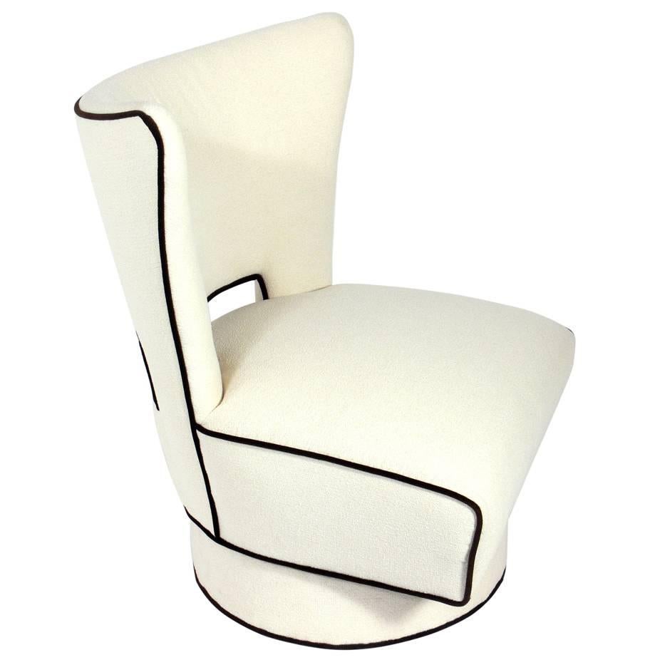 Large Scale Modern Swivel Lounge Chair, circa 1950s. It has been reupholstered in an ivory color boucle fabric with a dark brown velvet trim. 