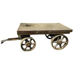 An industrial cart with handle and four iron wheels.