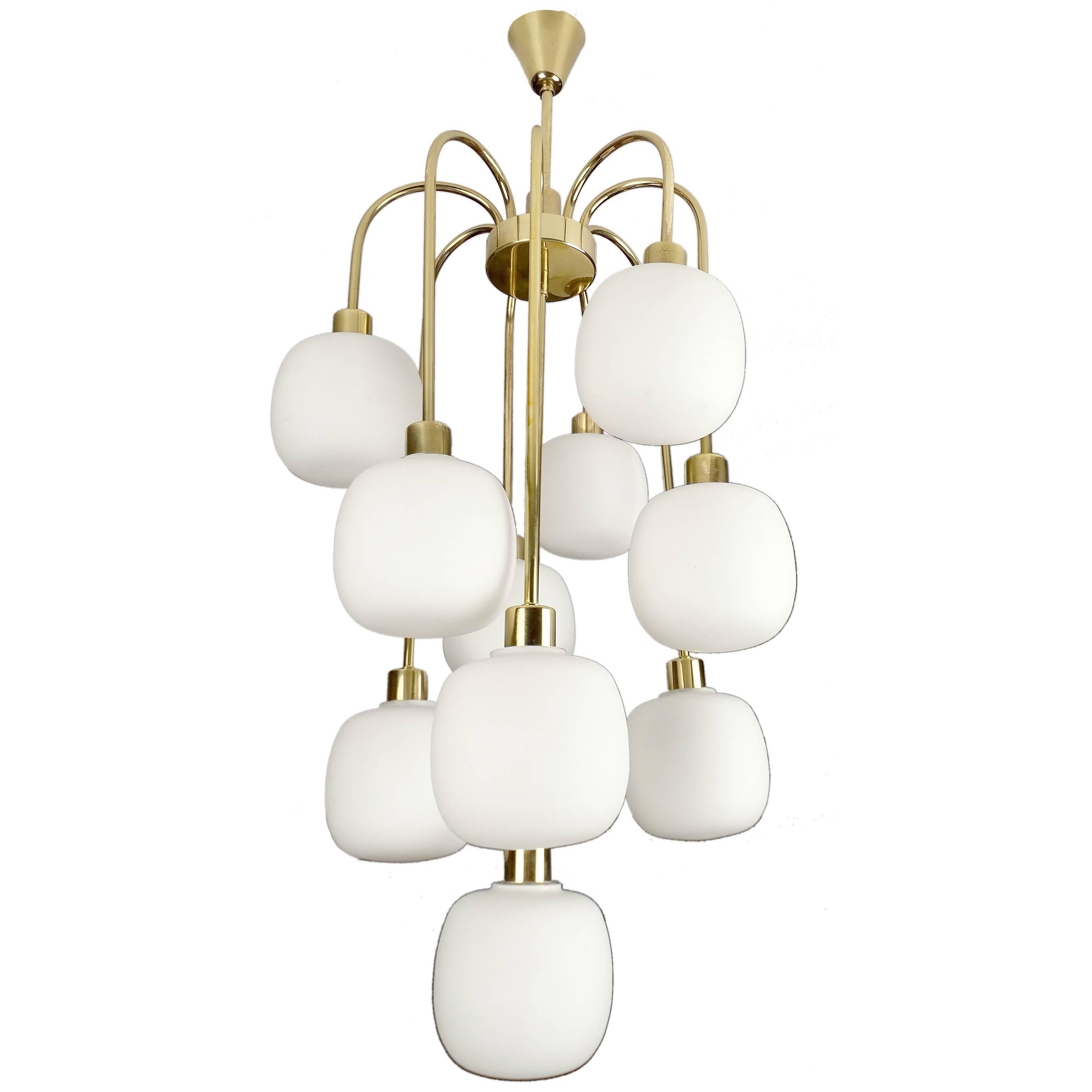 Very unusual Italian midcentury Cascade style chandelier, featuring nine glass globes on a waterfall four-tier brass structure.

Dimensions
33.07 in. H / 84 cm H
Diameter
14.57 in. (37 cm)

Nine candelabra size bulbs, 40 watts each, LED