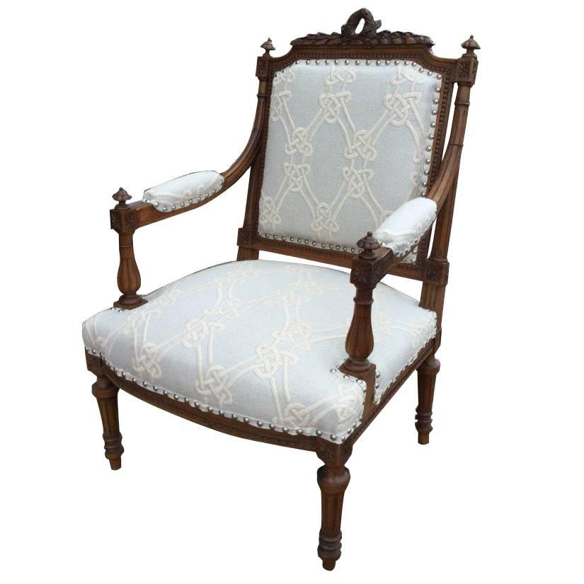 Pair of 19th century Louis XVI style walnut chairs. The frames are delicately
carved and feature a crown at the top, fluted legs and finials, re-upholstered in heavy Italian embroidered white linen in a trellis pattern and finished silver