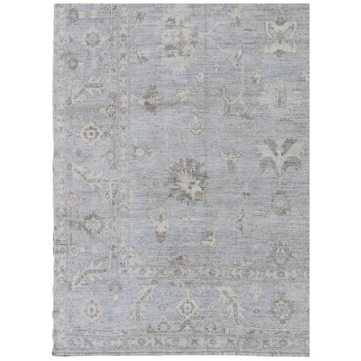 Made with a combination of angora wool and old wool, this magnificent Turkish Oushak boasts an all-over design in a large-scale style. The plentiful floral and bouquet motifs create an open design, which is surrounded by a border containing defined