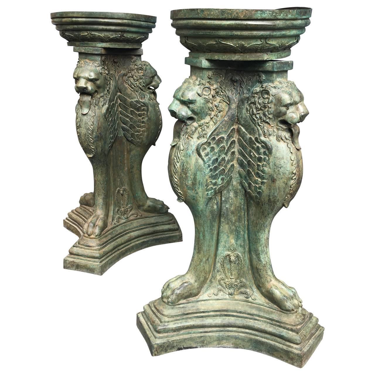 Large pair of urns in the shape of triple-winged griffins and clawed feet.