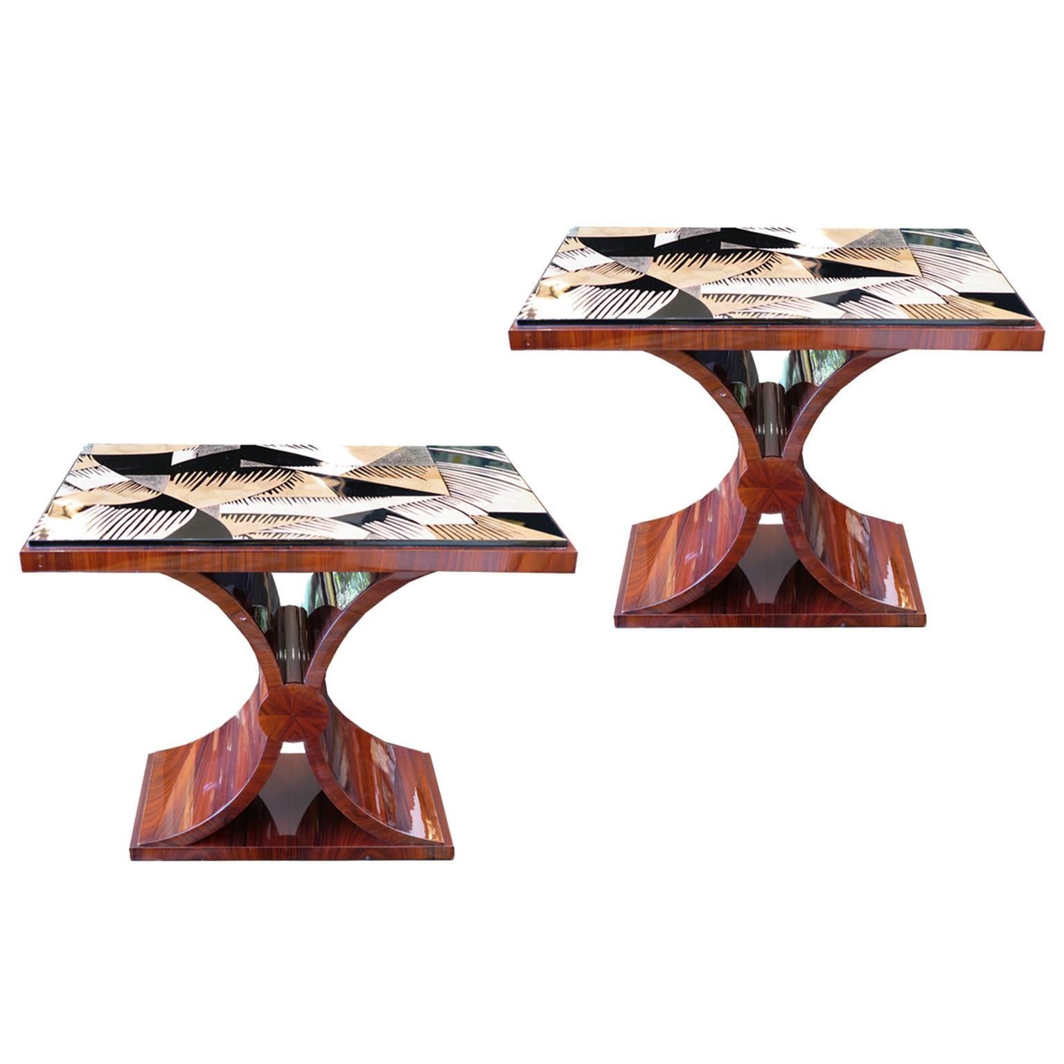 Iconic pair of side tables in the style of Art Deco. Featuring a lacquered rosewood base with an intricate and geometric eggshell inlaid top. Curved base in the shape of an x.