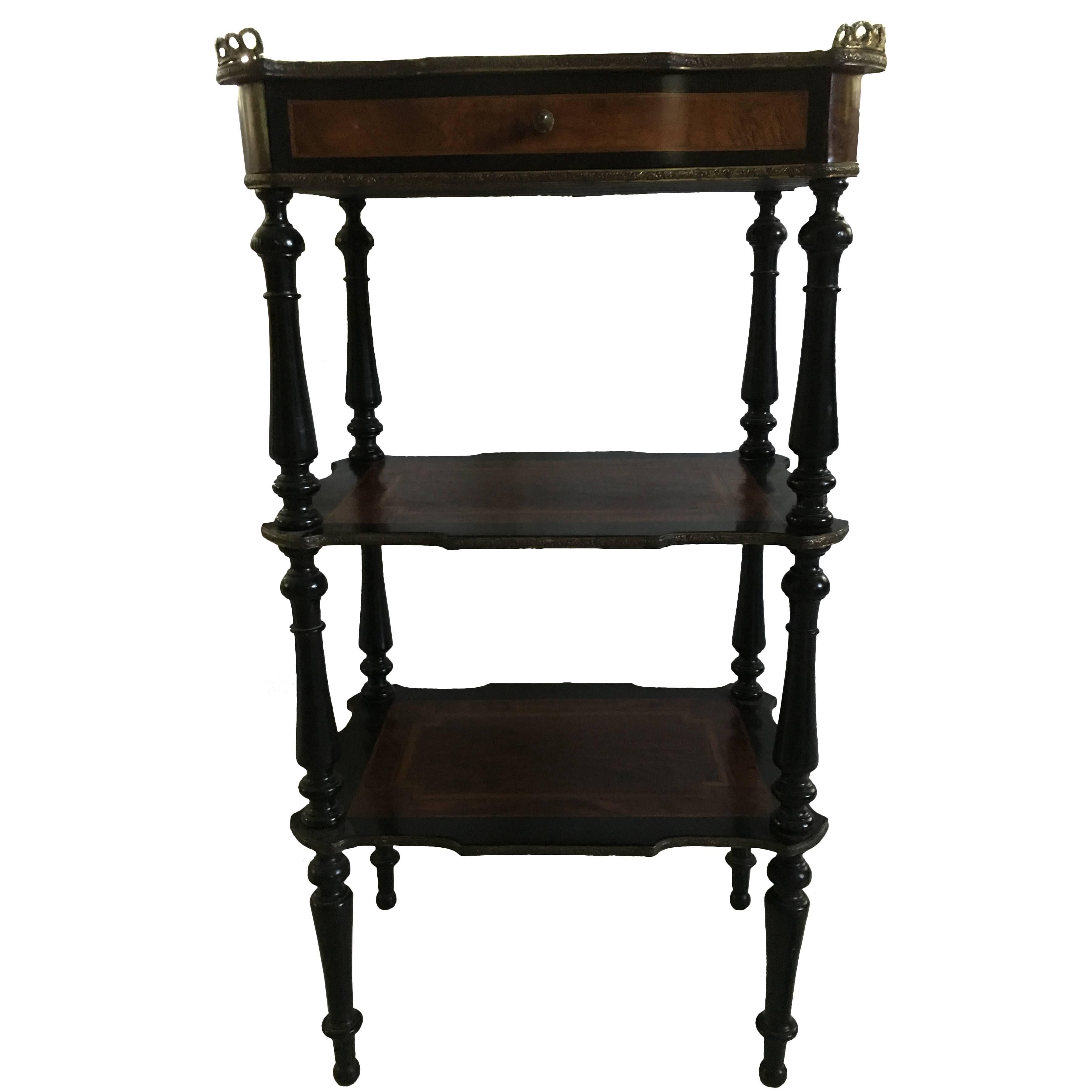 Beautiful 19th century French three-tiered stand or side table with marquetry. Each shelf has burled mahogany and ebonized wood marquetry with a brass gallery. One top drawer with brass acorn pull.

NF