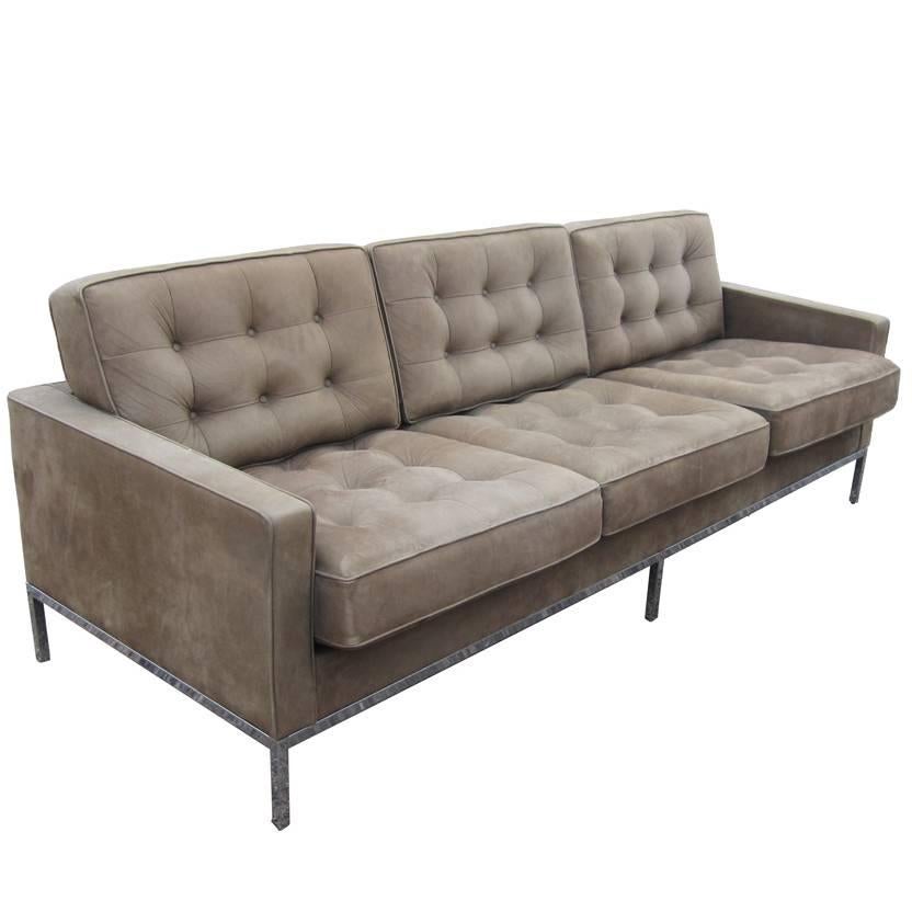 A Midcentury Knoll couch designed by Florence Knoll. This three person sofa features a tufted, light brown leather upholstery that looks like suede with chrome plated steel legs. This Classic design is perfect for any modern space. Measures: 90