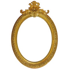 Marco de espejo ovalado de madera dorada y gesso tallado estilo Luis XVI francés del siglo XIX