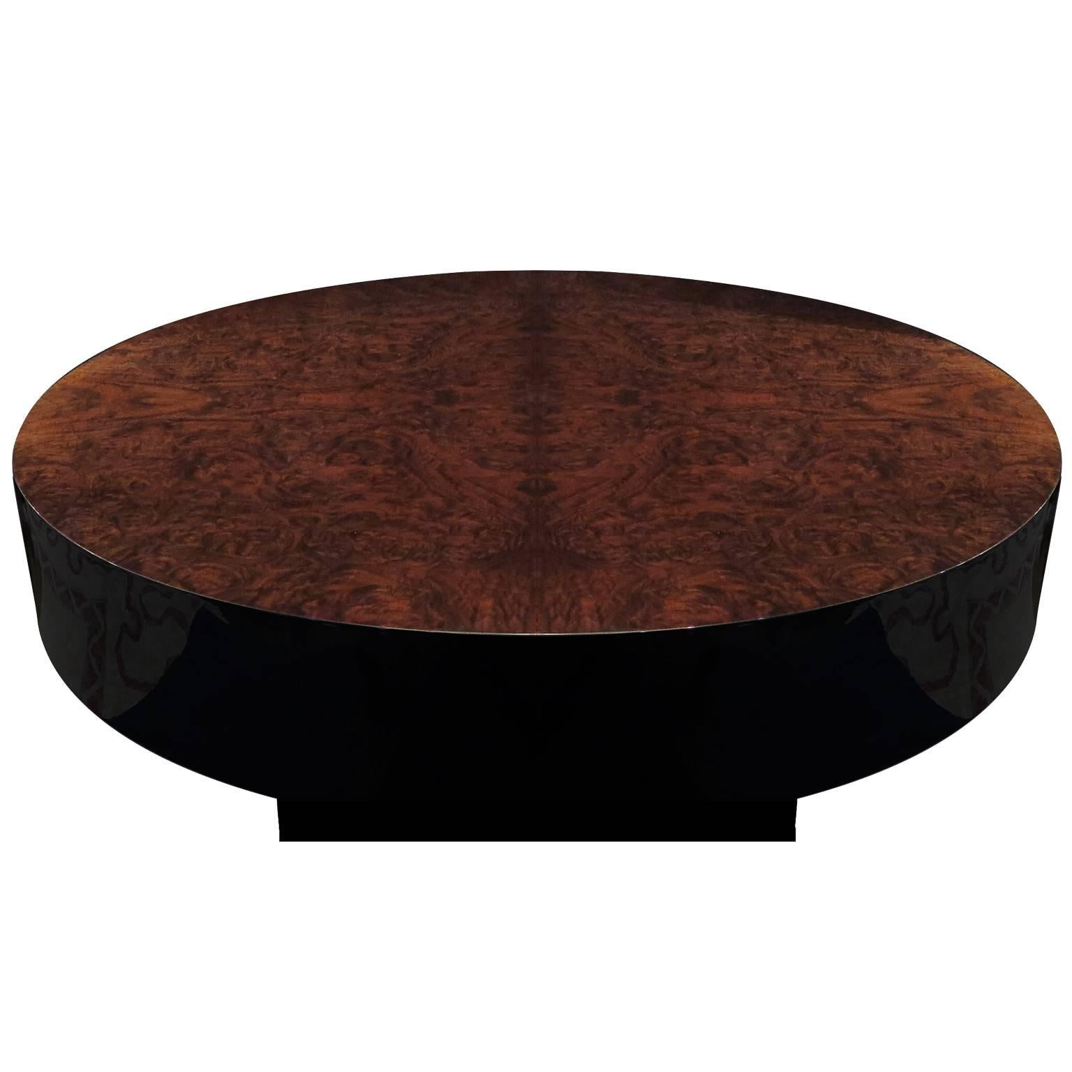 Round Mid-Century coffee table in beautiful walnut burl veneer on top with black lacquer frame and base. Coffee table pulls out to an inside bar. Interior holds glasses and decanters as well as other barware. Brass detailing on top edge of interior