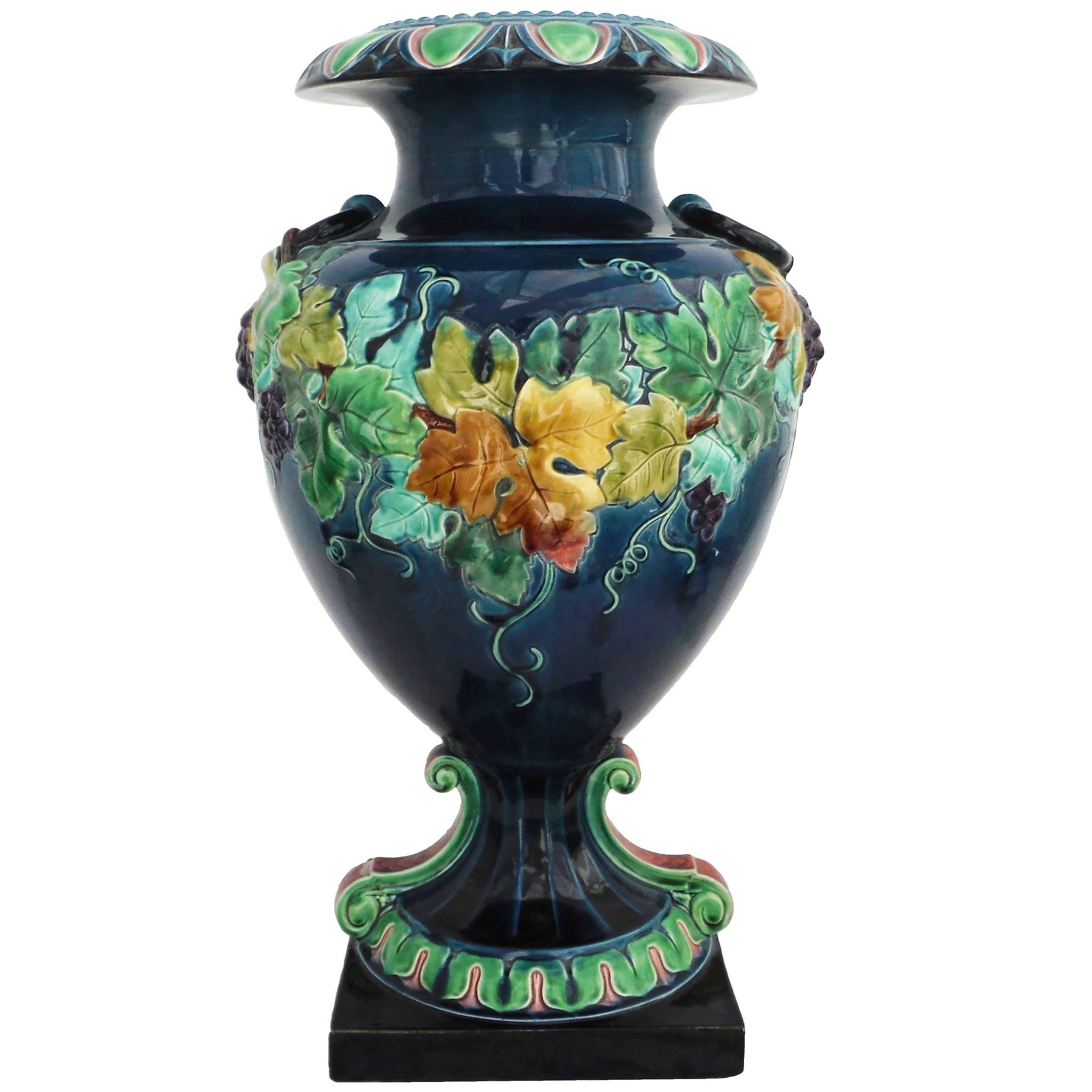 vase monumental français du 19e siècle en majolique bleue avec de grandes feuilles de vigne et un support de fruits ; deux grands anneaux en trompe-l'œil sur les deux côtés.
Ce vase est caractéristique du renouveau de la Renaissance à la fin du XIXe