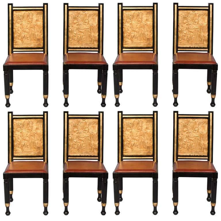 Ensemble de huit chaises de salle à manger d'inspiration égyptienne peintes et dorées