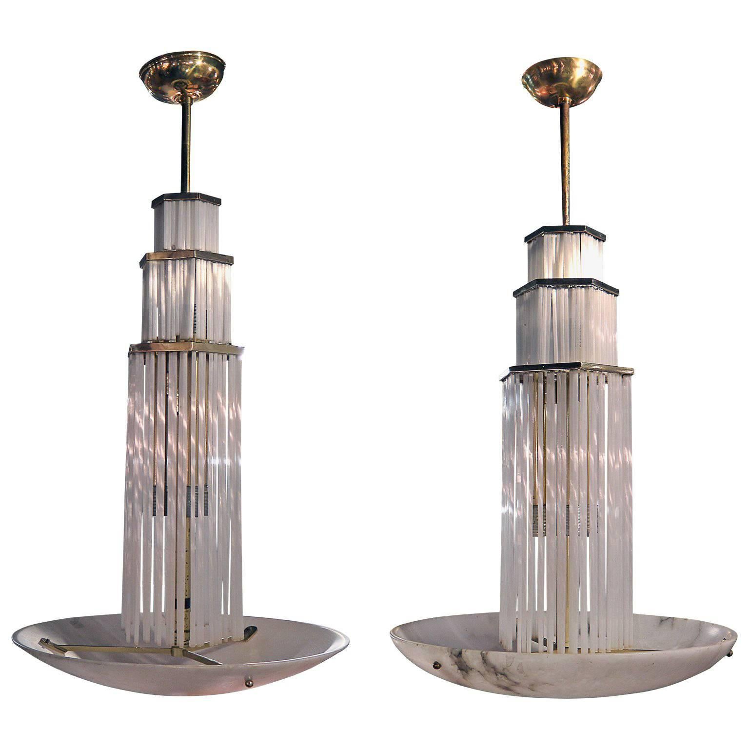 These two towered Art Deco beauties have three tiers with alabaster, glass rods which give of an amazing light patter look and glow beautifully. The marble base of the chandeliers has amazing wear and patina to add to it beauty and is connected by