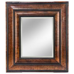 A Baroque Ebonized and Burl Walnut Mirror 