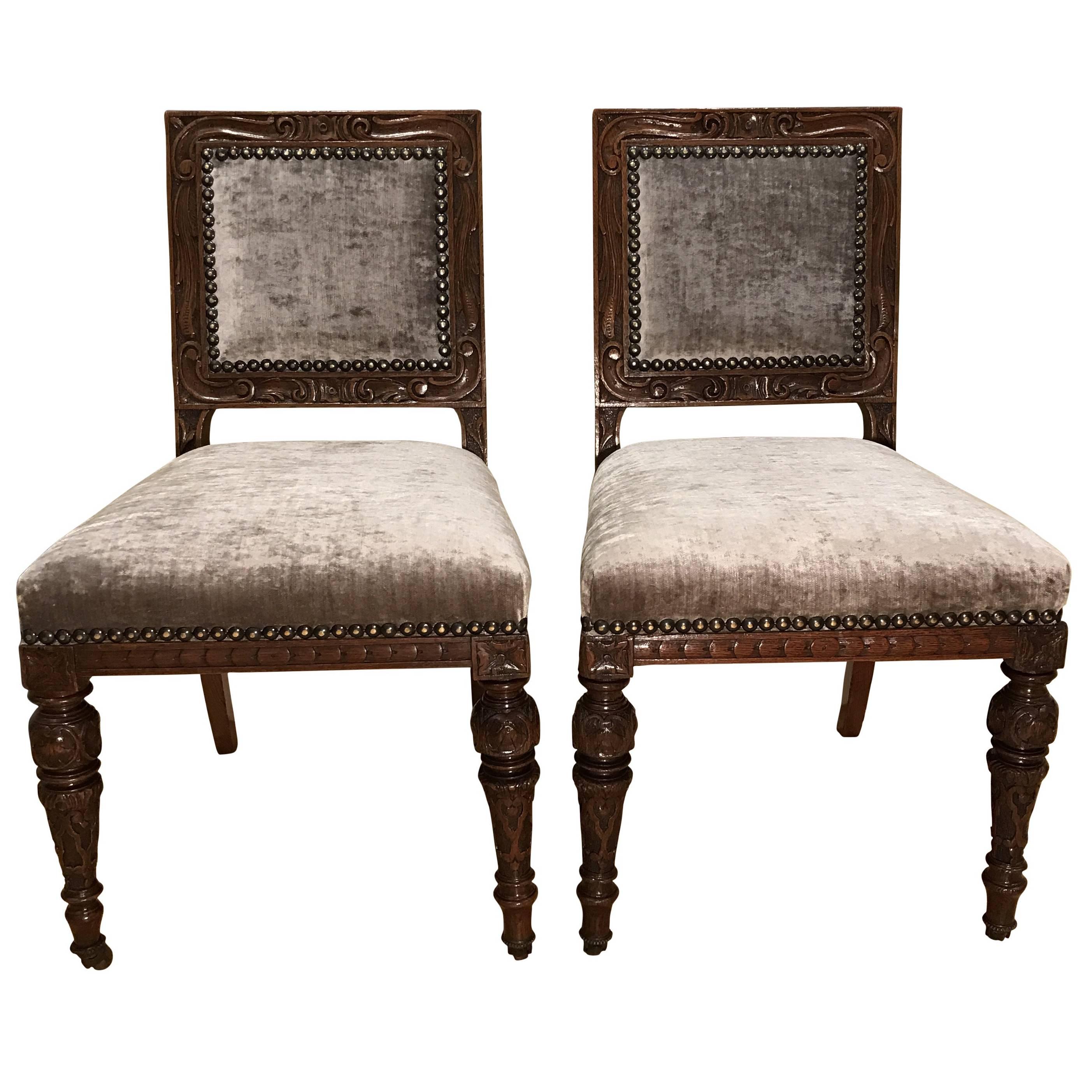 Beautiful set of twelve early Victorian carved oak dining chairs recently re-upholstered in a hard wearing easy to clean mink velvet fabric with brass stud surround. They are deep mahogany in colour.  Attributed to Gillows.