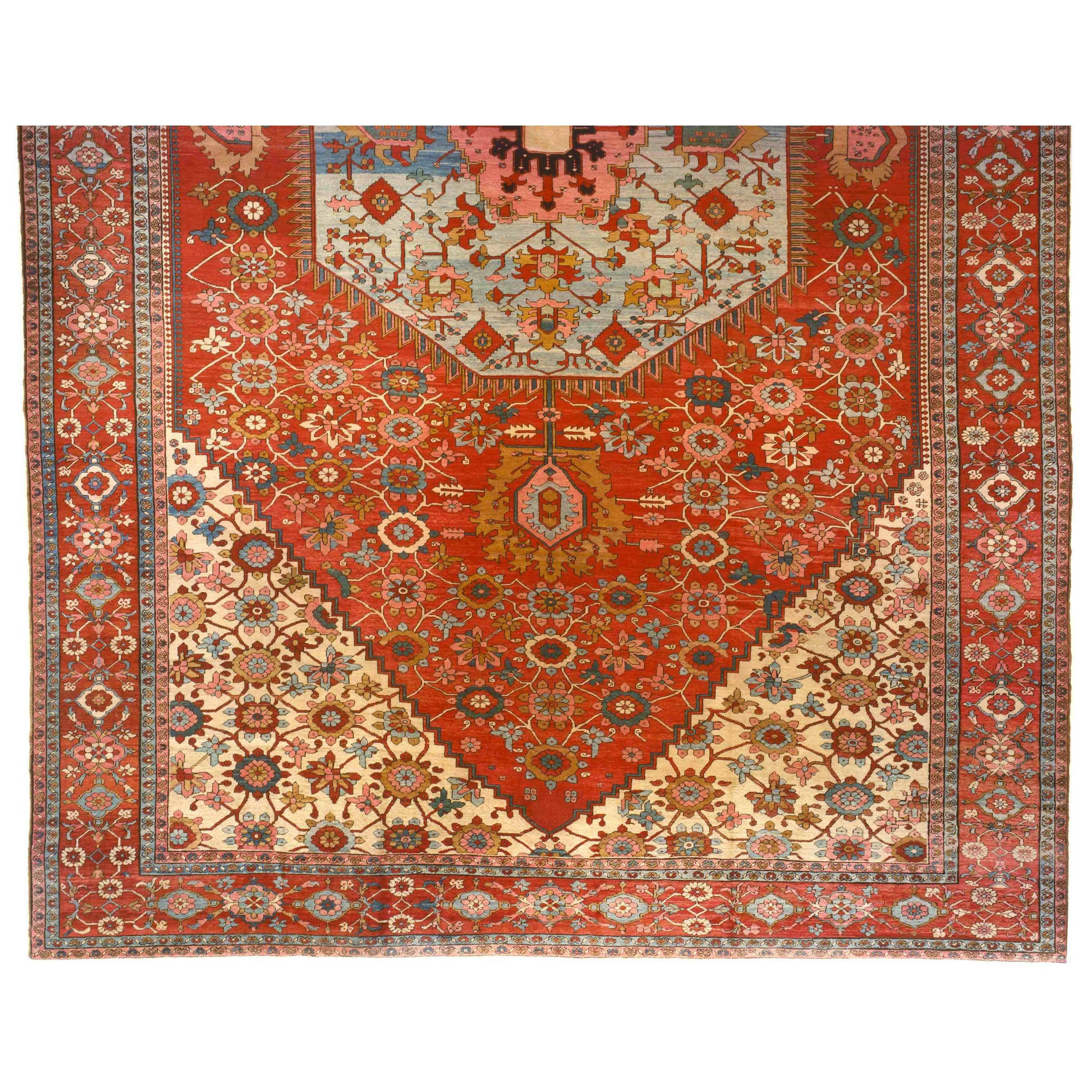 An antique Persian Serapi oriental carpet, size: 25 feet H x 16 feet W, circa 1880. This unique hand-knotted wool carpet is characterized by its soft blue central medallion, which sits amidst a sea of soft red, and is anchored by ivory corner