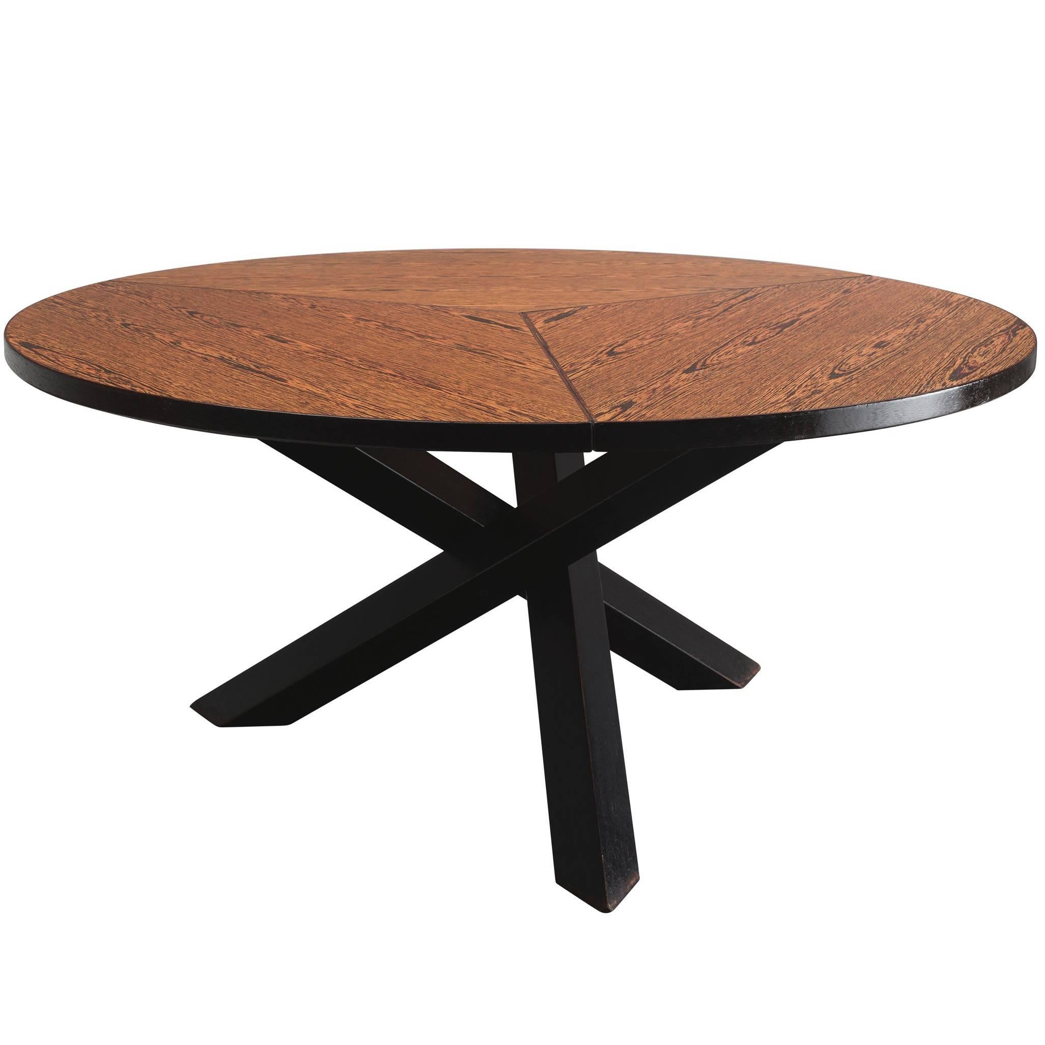 Dining table, in Wengé by Martin Visser for 't Spectrum, the Netherlands, 1960s. 

Beautiful patinated dining table with round top, divided into three parts. The base consist of three crossed legs of solid, dark stained wood. The veneer top shows