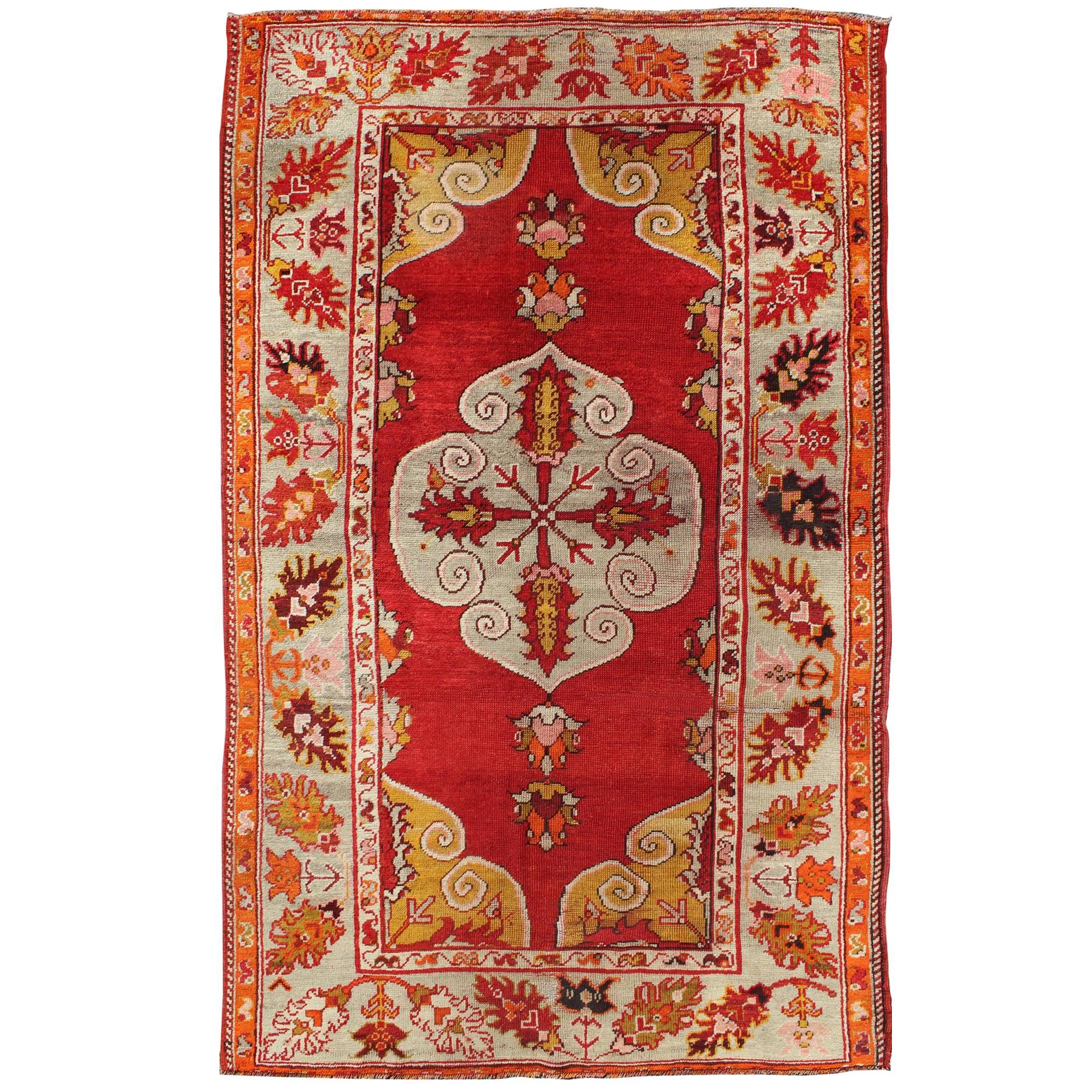 Antiker türkischer Oushak-Teppich mit Medaillon in der Mitte aus Medaillon mit rotem Grund und mehreren Farben