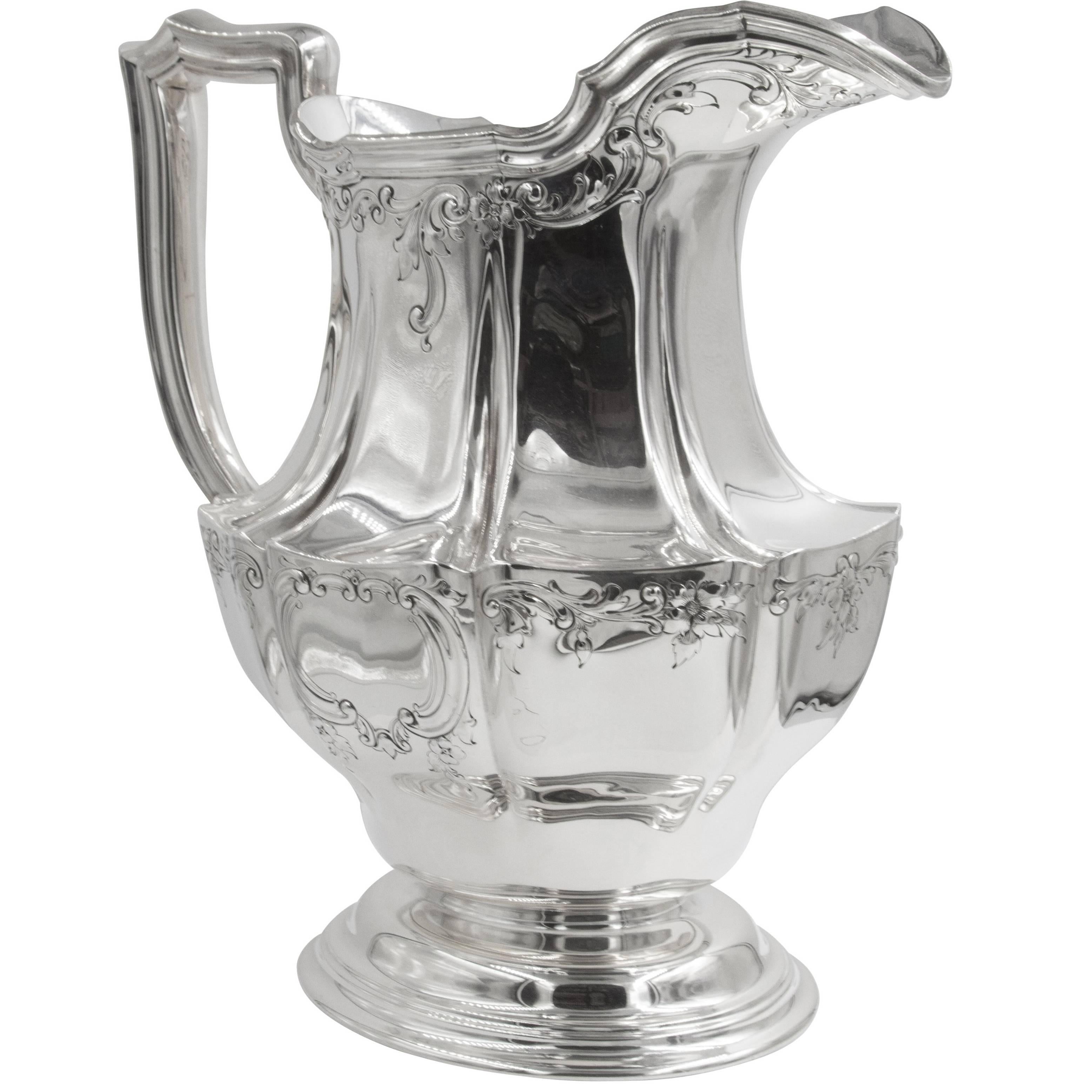 Oval shaped with delicate etching around the top and middle of the pitcher. Notice the elegant shape of the handle and the indentations throughout the body. This piece is sure to catch everyone's attention!
