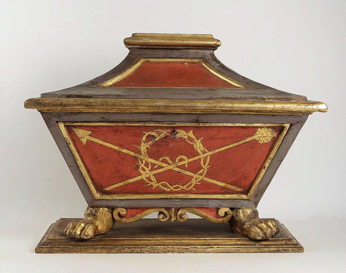 We are pleased to present you a very decorative trunk, in lacquered red, grey and gold hand-carved wood, decorated with the attributes of the Passion.
Our trunk rests on beautiful claw feet on a solid foundation. The trunk may be