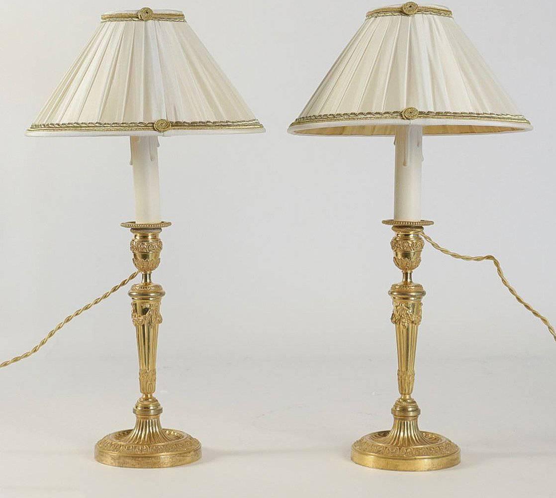 We are pleased to present you a lovely pair of French Louis XVI style, original mercure gilt bronze candlesticks, very finely chiseled with foliages, grapes, water pearls, converted to table lamps, with new French pleated changeable white color silk