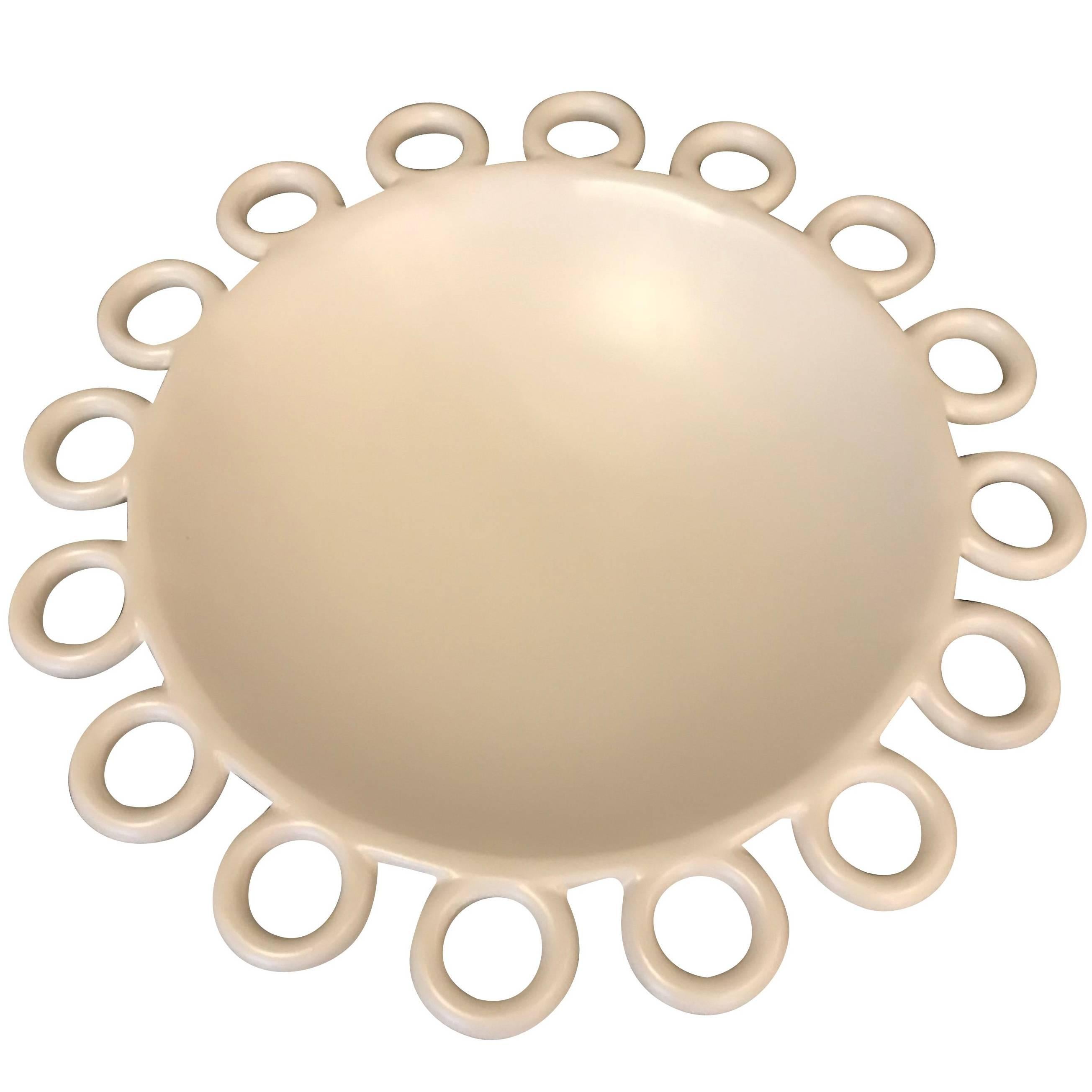 Contemporary French white matte bowl with circles forming perimeter.
 