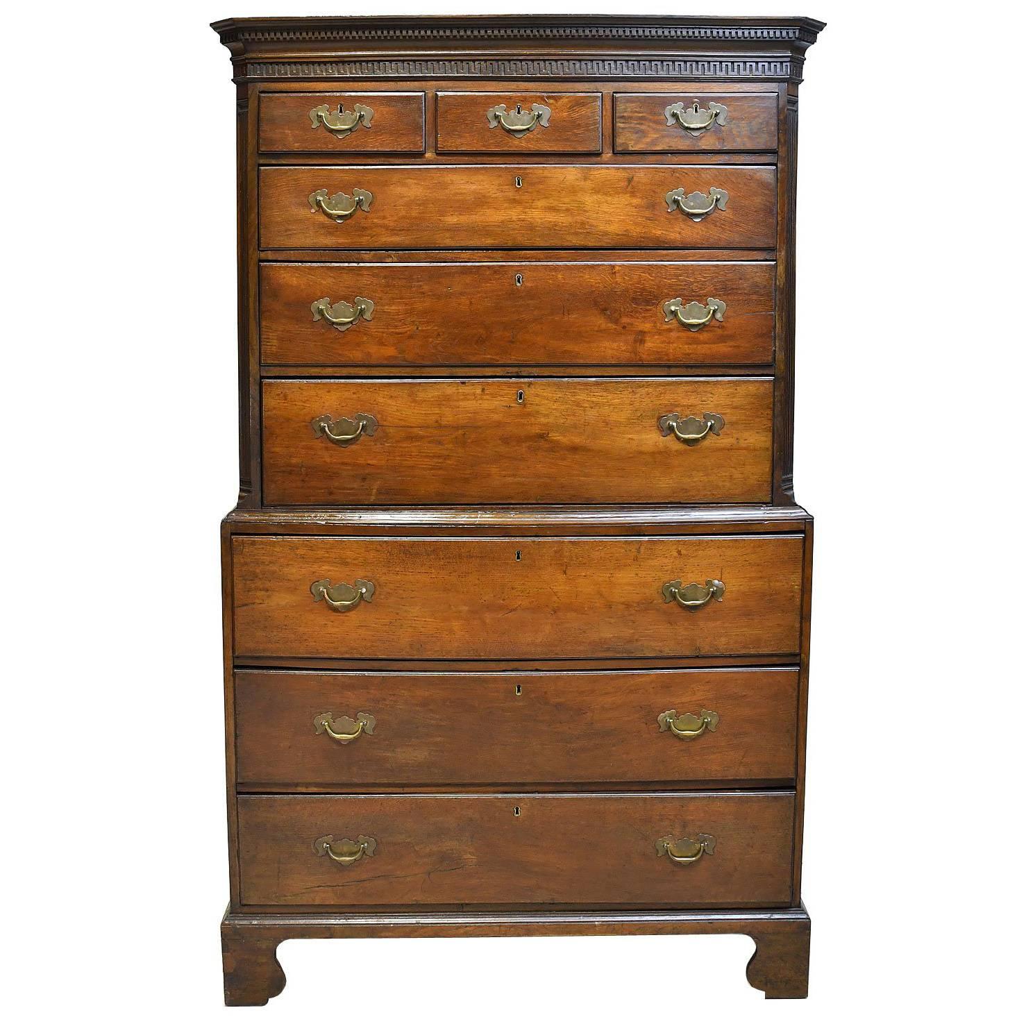 A very handsome early Georgian highboy or chest on chest with dentil moulded cornice above Greek-key moulding, with three drawers over six graduated drawers with original brass escutcheon plates and swan-neck bail handles. The bottom drawer of top