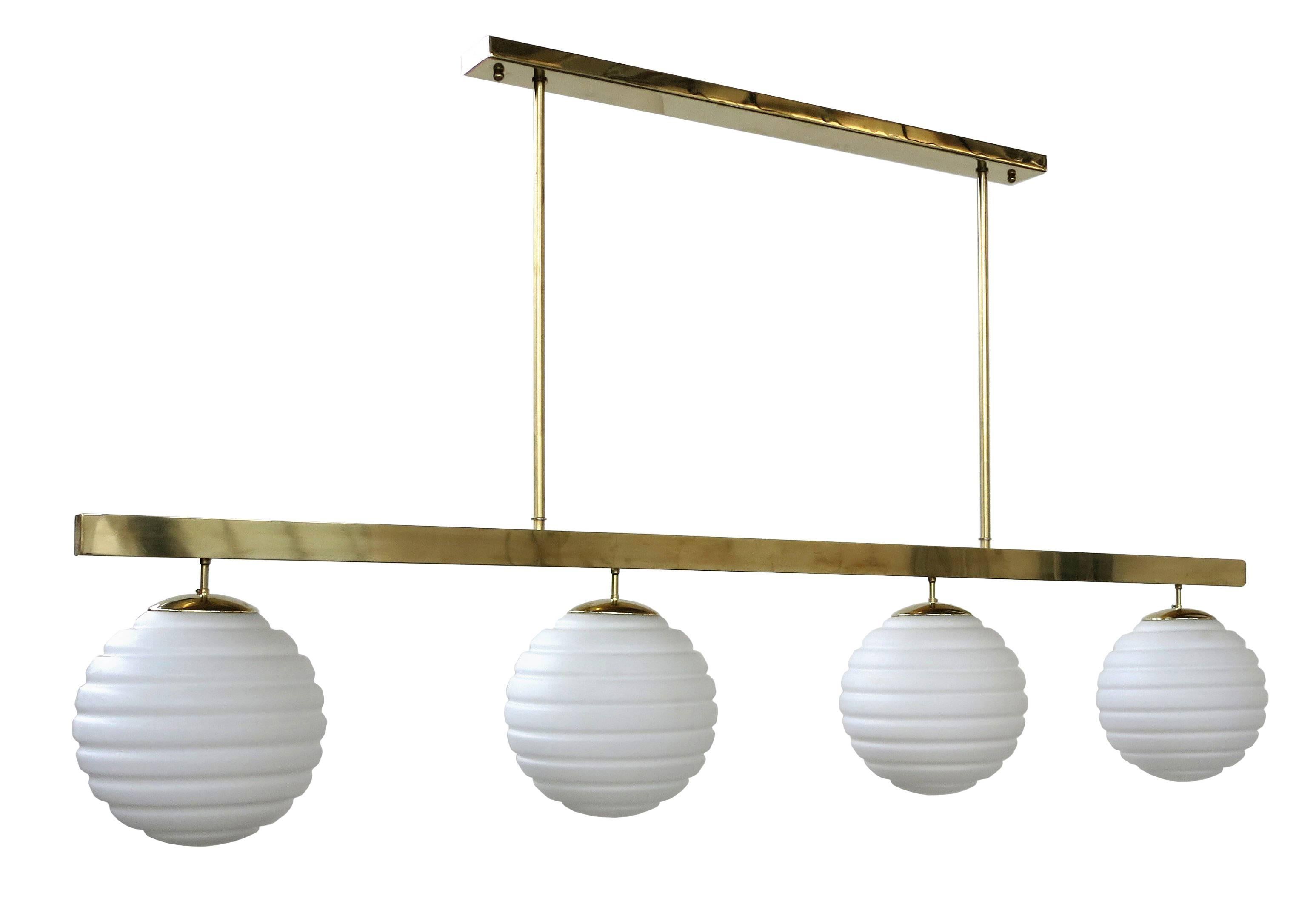 Italian pendant chandelier shown in white ribbed Murano glass globes, mounted on polished brass frame / Designed by Fabio Bergomi for Fabio Ltd / Made in Italy
4 lights / E26 or E27 type / max 40W each
Height: 41.5 inches including rods and canopy /