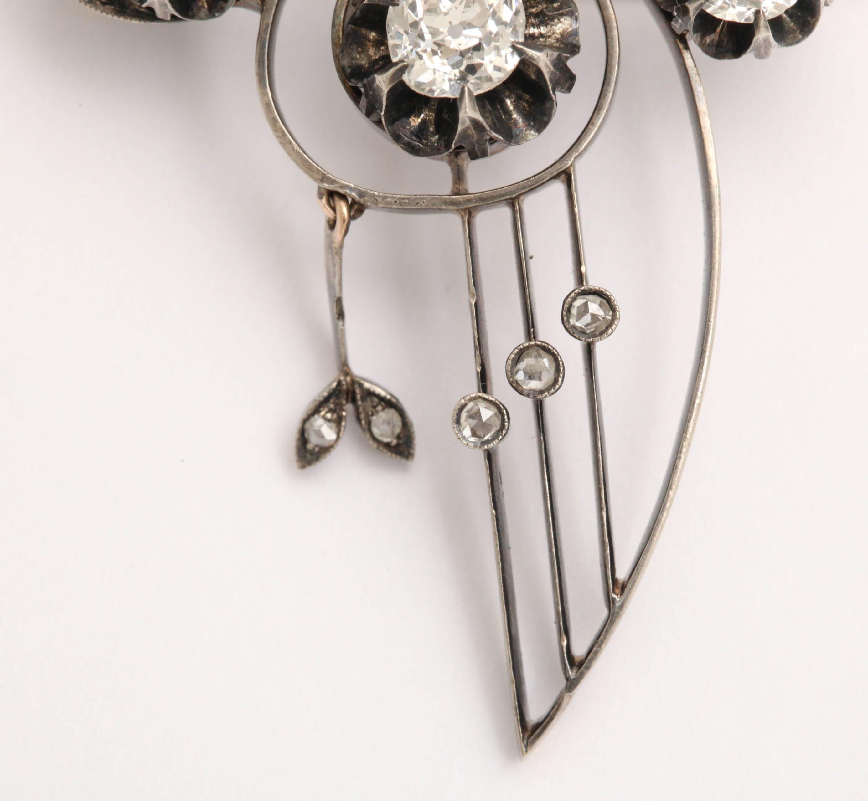 An Art Nouveau pendant necklace with three European rose cut diamonds approximately .50cts each and smaller european and rose diamonds 
comprising the flower motif.  18k white and yellow gold. 
