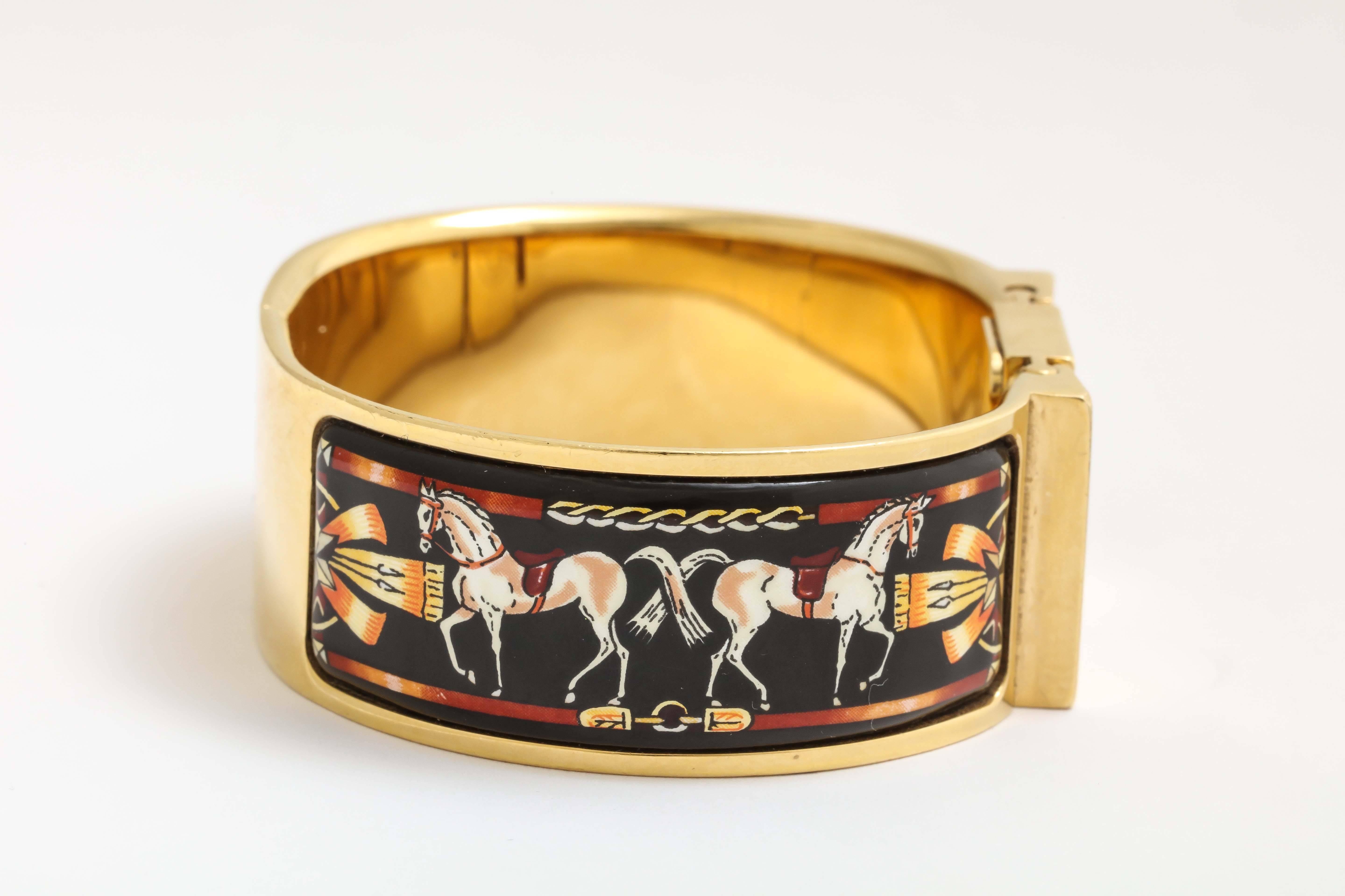 A stylish Hermes enameled bangle watch with equestrian theme images.