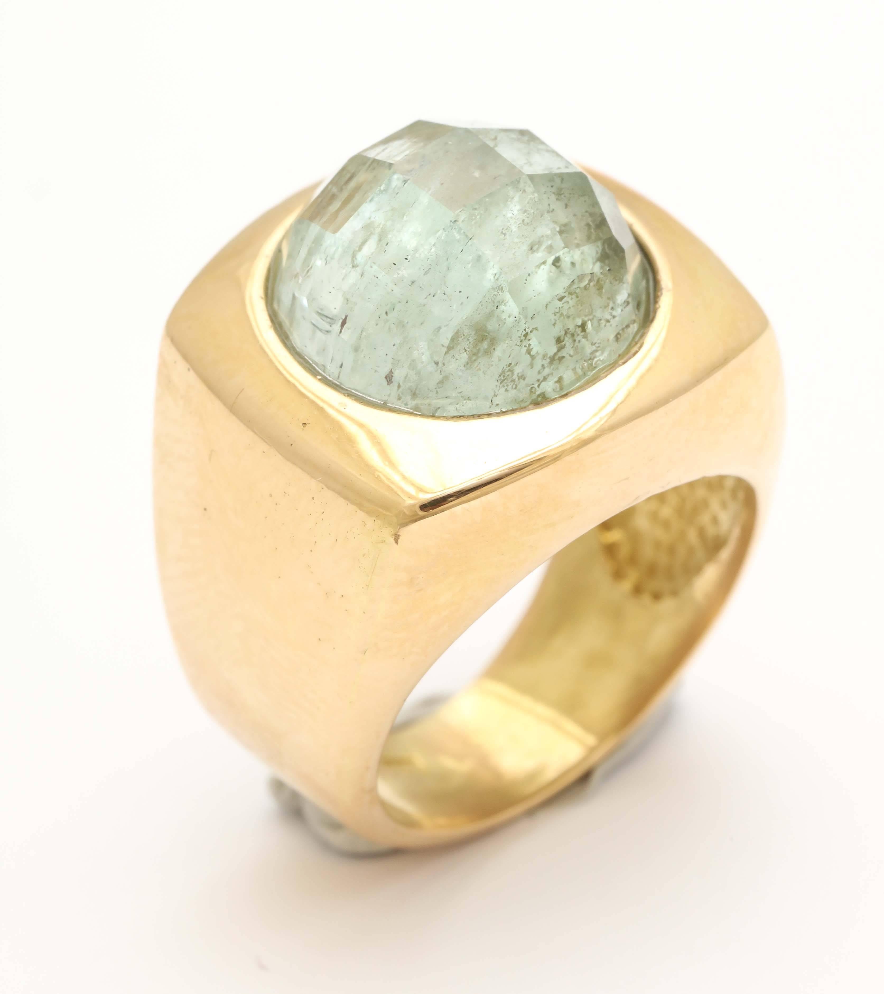 A fabulous designer ring in 18 kt gold with a interesting faceted rutilated quartz in a modernist setting.  This is a classical look with an exceptional design.