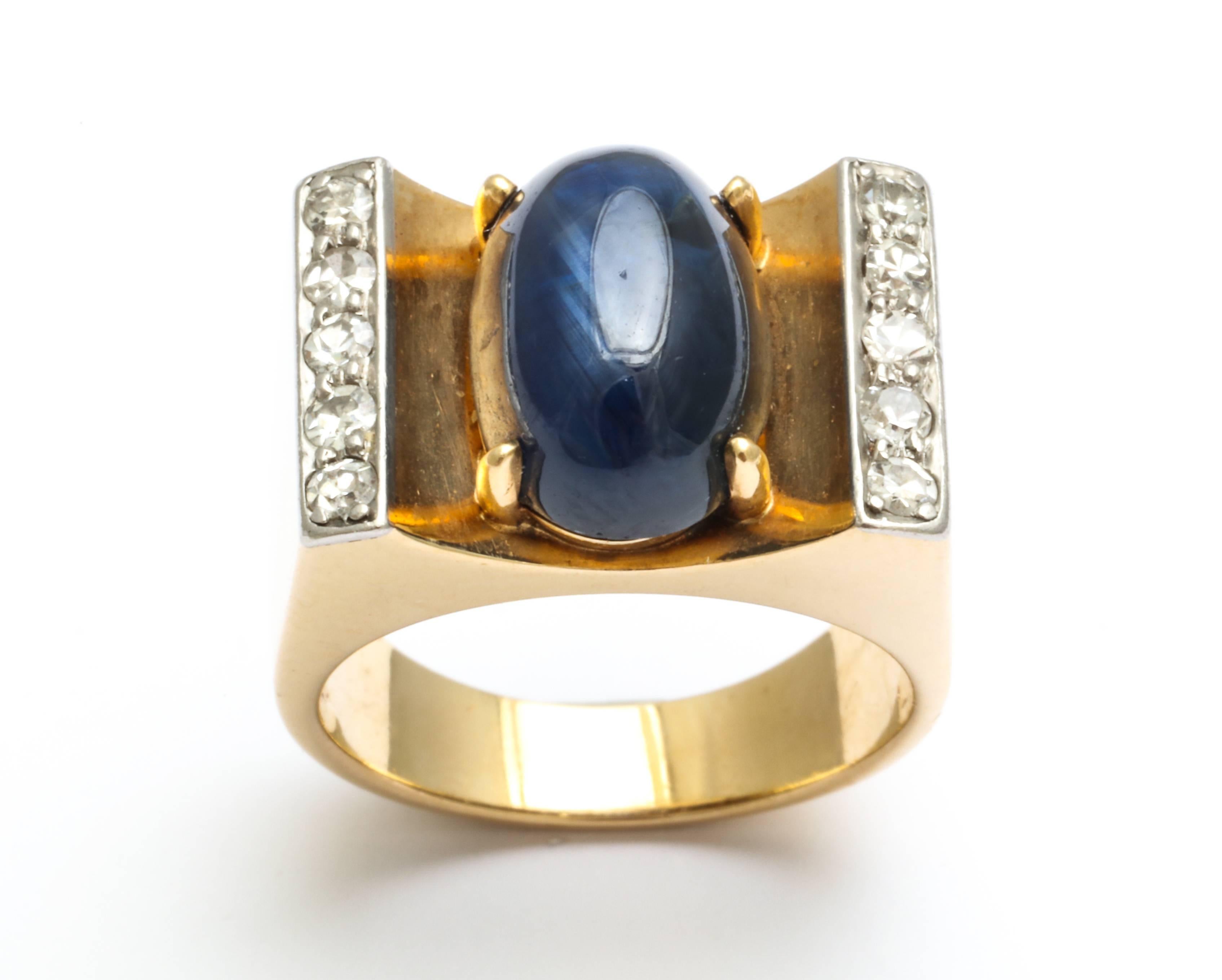 A stunning Art Deco ring with a natural cabochon sapphire flanked by two rows of five diamonds set in 18-karat gold. This ring is signed Traubert Hoefer Mauboussin.