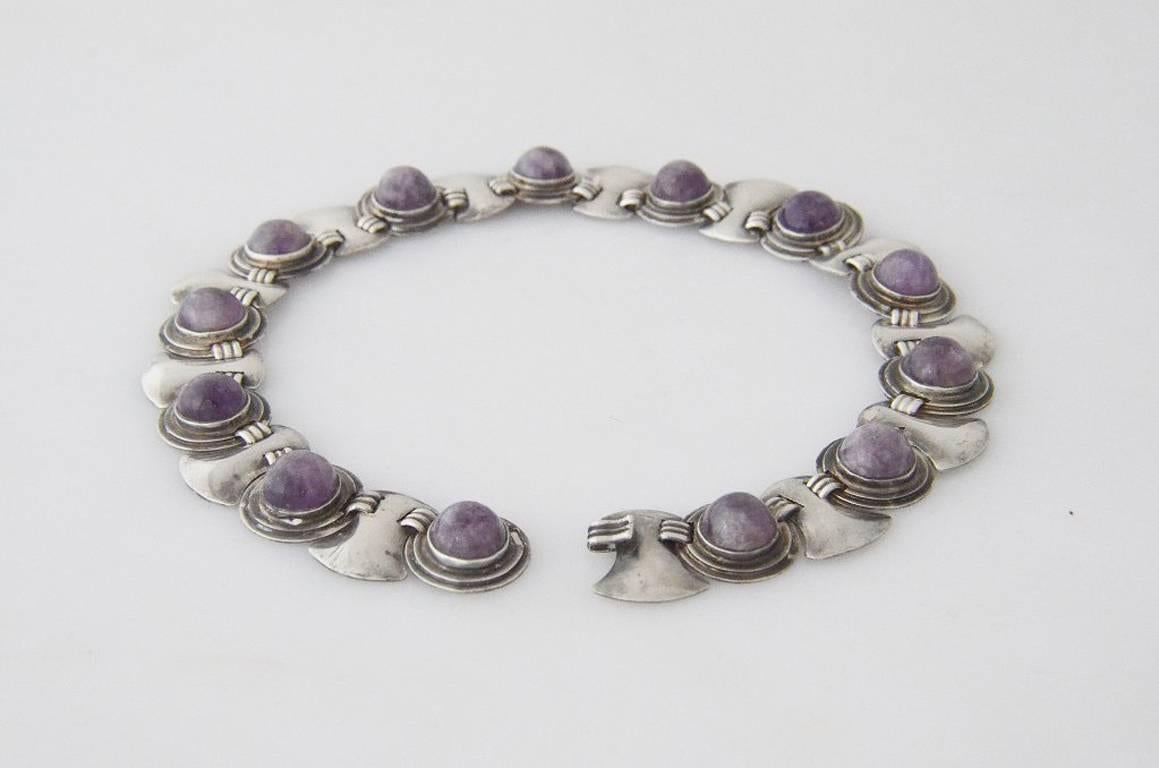 Being offered is a circa 1930 sterling silver necklace by Fred Davis, of Taxco, Mexico, the necklace is set with thirteen colorful natural purple round raw amethst stones approx 1/2" in diameter by 1/4+ tall.  Necklace features a round and