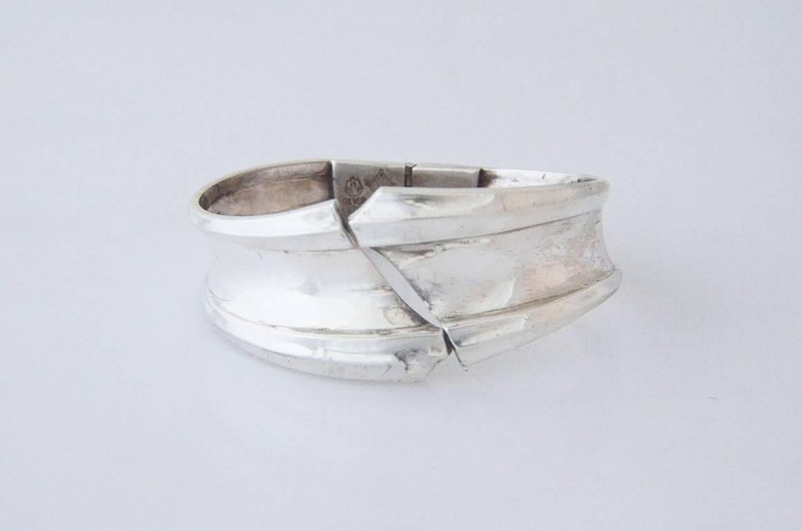Being offered is a .970 silver bracelet by Antonio Pineda, of Taxco, Mexico, in his quintessential bold modernist motif,   This is one of the few 'clamper' style bracelets that the master designed.   It opens at the front and is hinged at the back. 