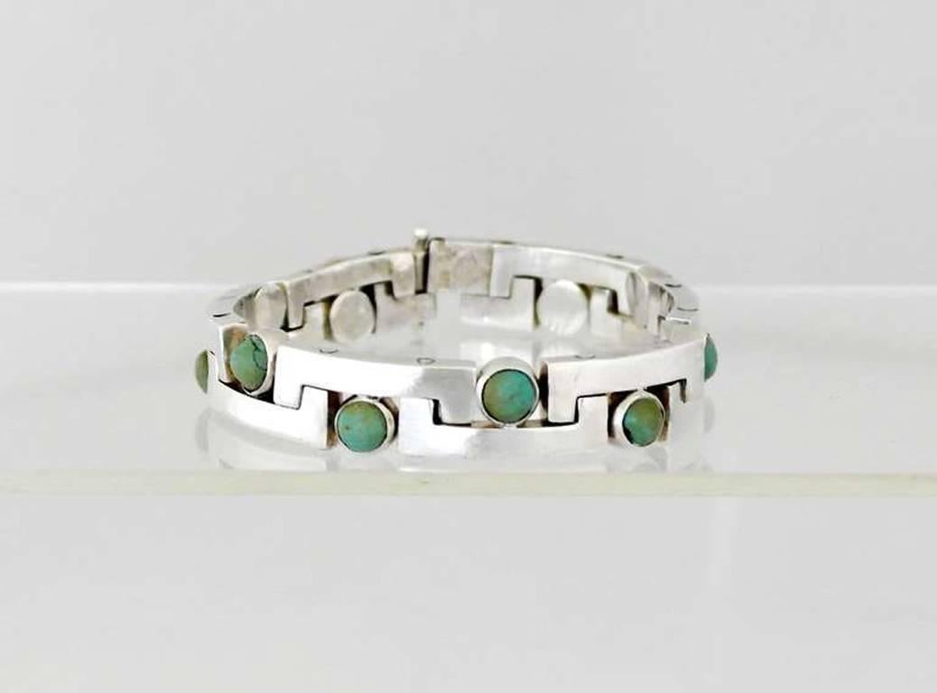 Being offered is a circa 1960 .970 silver modernist bracelet by Antonio Pineda of Taxco, Mexico. Interlocking links decorated with Mexican jade stones; tongue & box closure. Length 8 1/4" long x 1/2" wide (inner circumference 7").