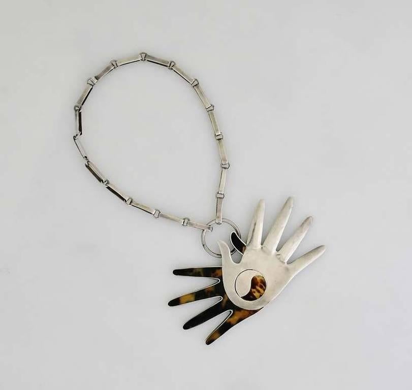 Being offered is a rare circa 1951 necklace by William Spratling of Taxco, Mexico. Necklace with one shell & one silver hand; a ying yang applied motif at the center; attached to a silver link chain. Dimensions:  necklace 16 1/2 inches long
