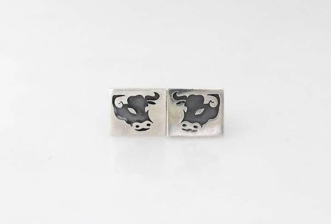 Being offered are a pair of circa 1967 .970 silver cufflinks by Antonio Pineda of Taxco, Mexico; pierced bull design with oxidized surface resembling a shadow box effect. Dimensions: 7/8" x 3/4". Marked as illustrated. In excellent