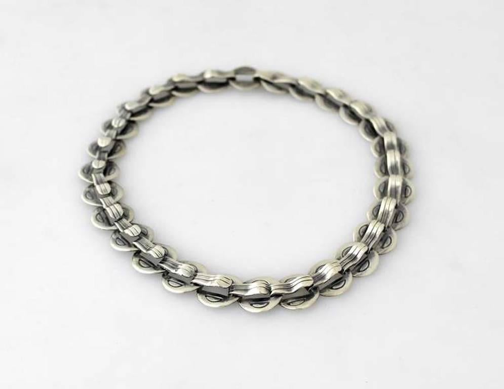 Being offered is a circa 1958 .940 silver necklace by Hector Aguilar of Taxco, Mexico. Handmade piece comprising circular curved links decorated with incised lines. Dimensions: 15 1/2" long x 5/8" wide. Marked as illustrated. In excellent