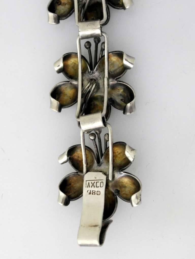 Being offered is a circa 1940s .980 silver bracelet from Taxco, Mexico. Handmade--incredibly chased--three dimensional floral motif links. Dimensions: 7" long x 1" wide; inside diameter 2". Marked as illustrated. In excellent