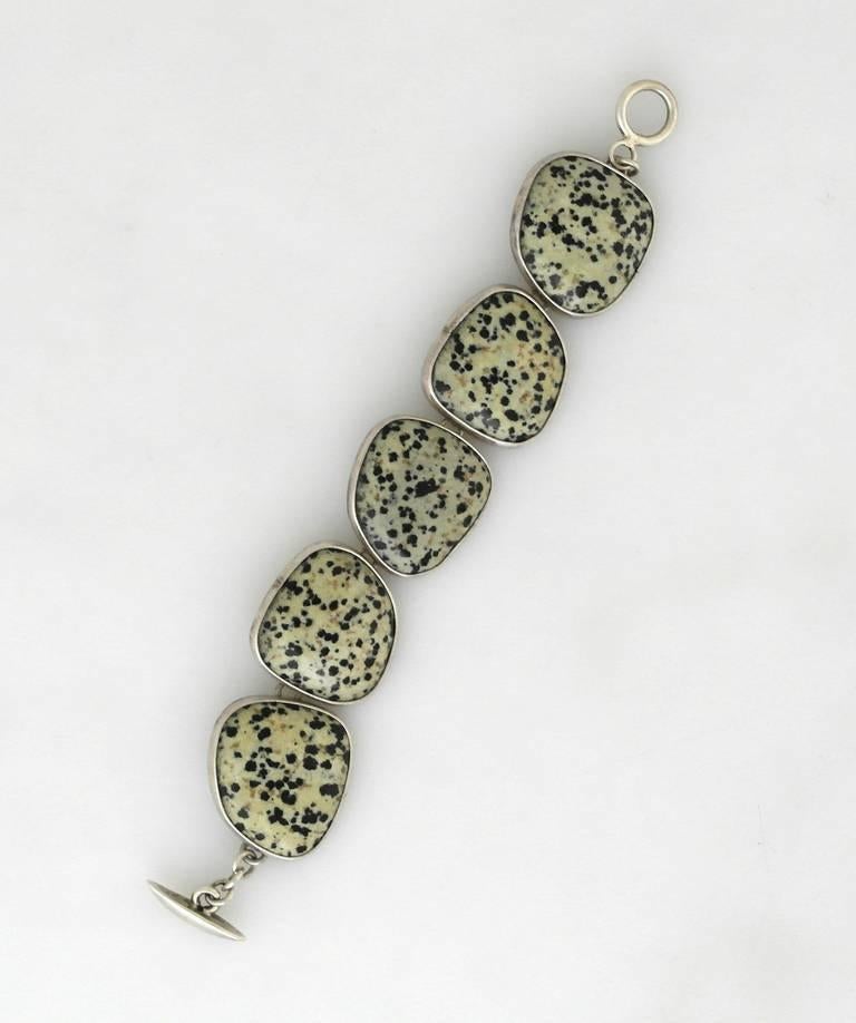 Being offered is a contemporary bracelet by Citlal Castillo, the niece of Antonio, founder of Los Castillo. A fine example of traditional design, each of the links decorated with fine jasper stones. Dimensions: 1" wide x 7 1/2" long (inner