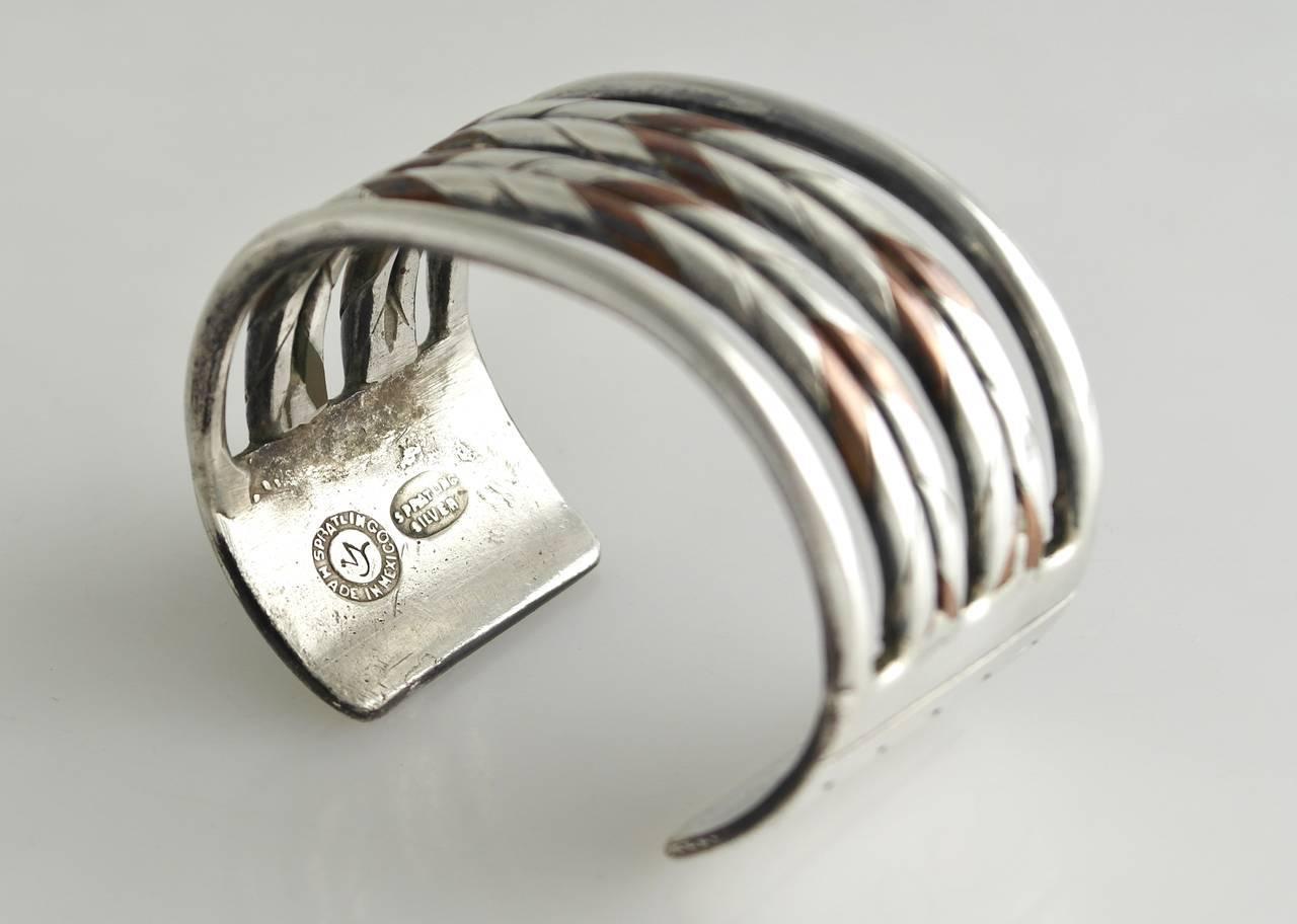 Being offered is a circa 1940 sterling silver cuff bracelet by William Spratling of Taxco, Mexico, comprising interwoven silver and copper bands designed of heavy gauge silver. Dimensions 6 14" inch wrist, 1 3/8" wide (inner dimensions