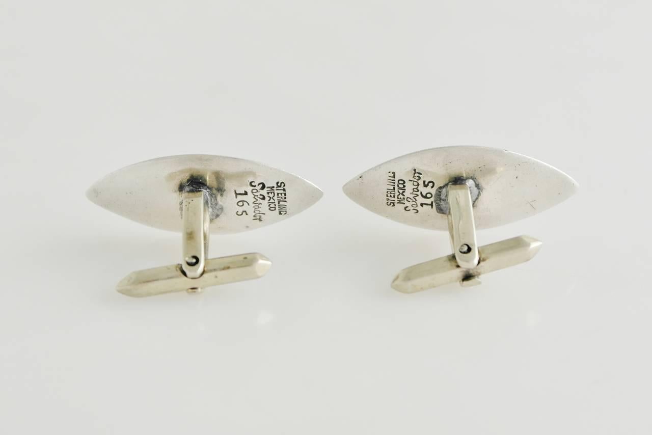 Being offered are a pair of sterling silver cufflinks by Salvador Teran of Taxco, Mexico, marquise shape cufflinks designed with a pre Colombian motif in a shadowbox setting. Dimensions:    Marked as illustrated. In excellent condition.

