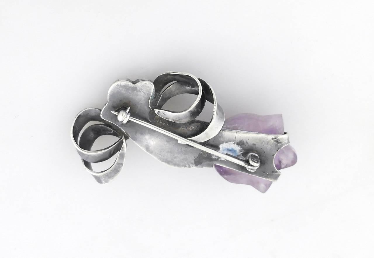 Being offered is a circa 1943 sterling silver pin by William Spratling of Taxco, Mexico. Pin bearing a hand motif holding an amethyst tulip. A matching bracelet is also available. Dimensions:              Marked as illustrated. In excellent