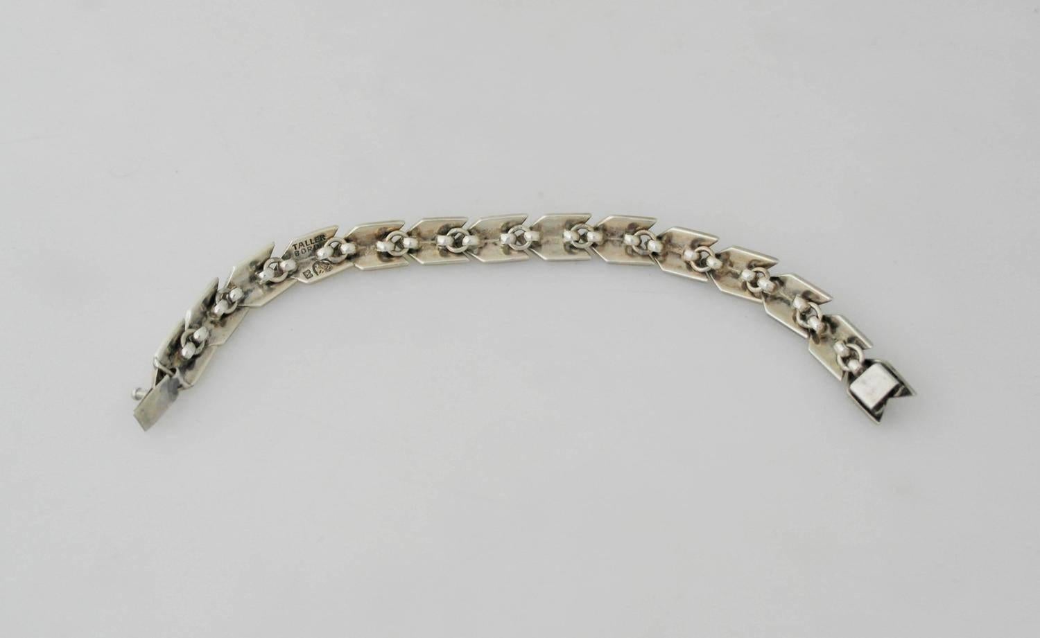 Being offered is a sterling silver bracelet by Hector Aguilar of Taxco, Mexico. Link bracelet manufactured at Aguilar's Taller Borda shop during the 1950s. Each link in a chevron design with a beaded accent. Dimensions: 1/2 inch wide x 6 3/4