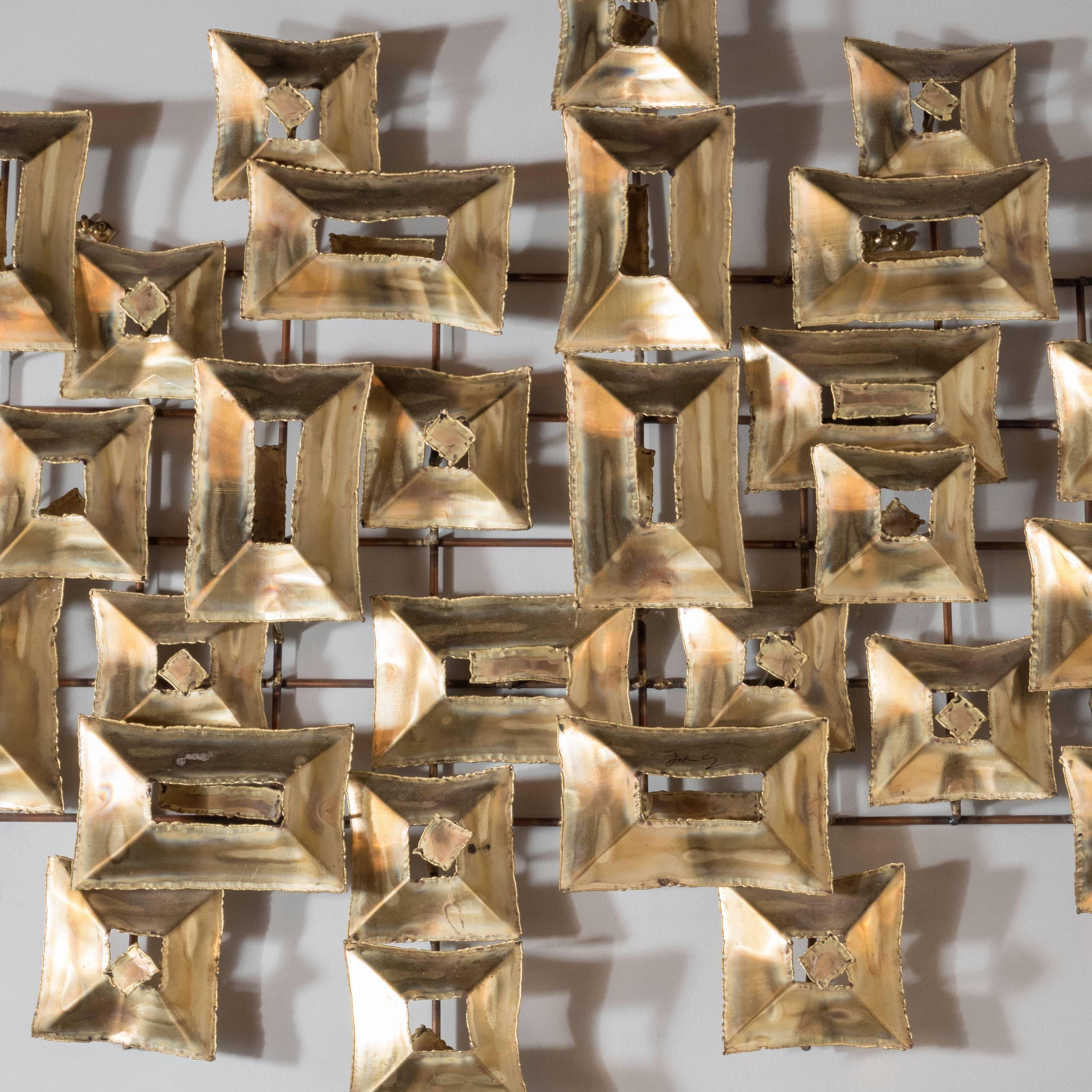 This stunning Brutalist wall sculpture by C. Jere with torch cut patined brass rectangular shapes that are invisibly affixed to the brass support, so as to give the impression of dynamic forms free floating in space. Mitchell Owens wrote for the