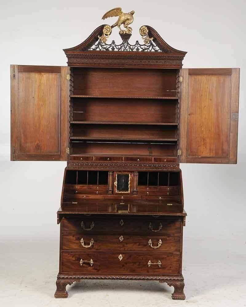 Period Chippendale George III Secretary Bookcase with Desk Interior

British, circa 1765, highly figured veneers, blind fretwork, leaf, and gadrooned carving, gilt finial rosettes and mirrored door surrounds, lower case with fitted desk interior,